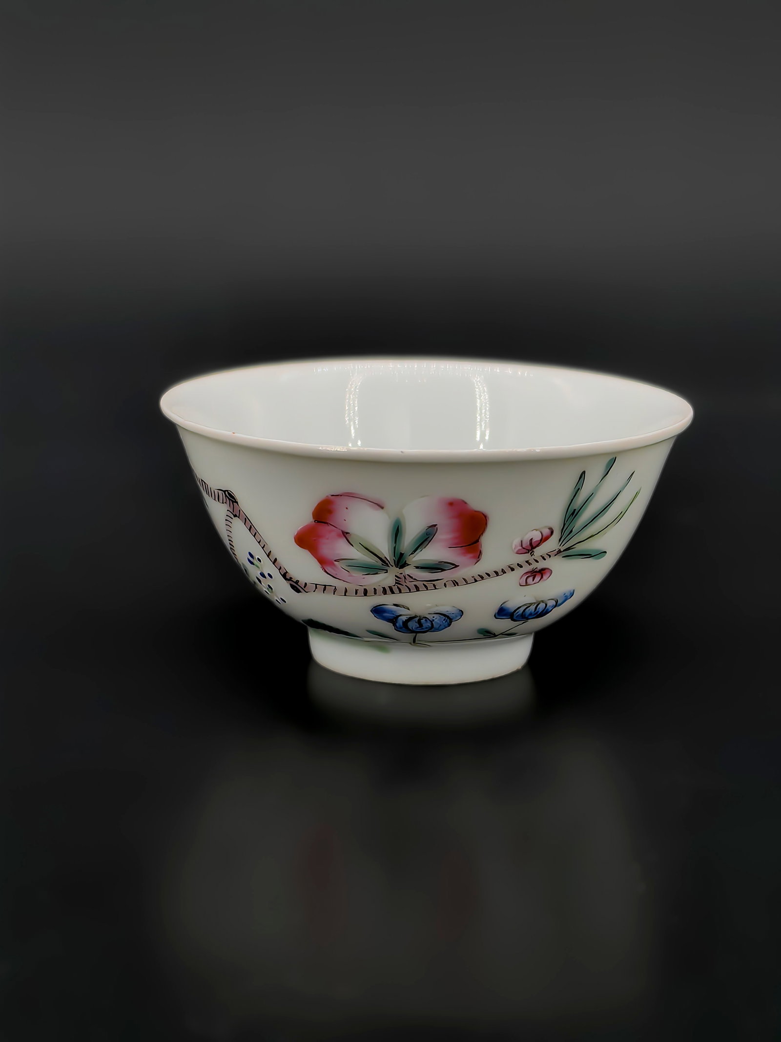 A Qing Dynasty Famille Rose Bowl: This finely potted bowl, measuring approximately 10cm in diameter, features a flared rim and a deep body. The exterior is exquisitely decorated in famille rose enamels with plum blossoms and