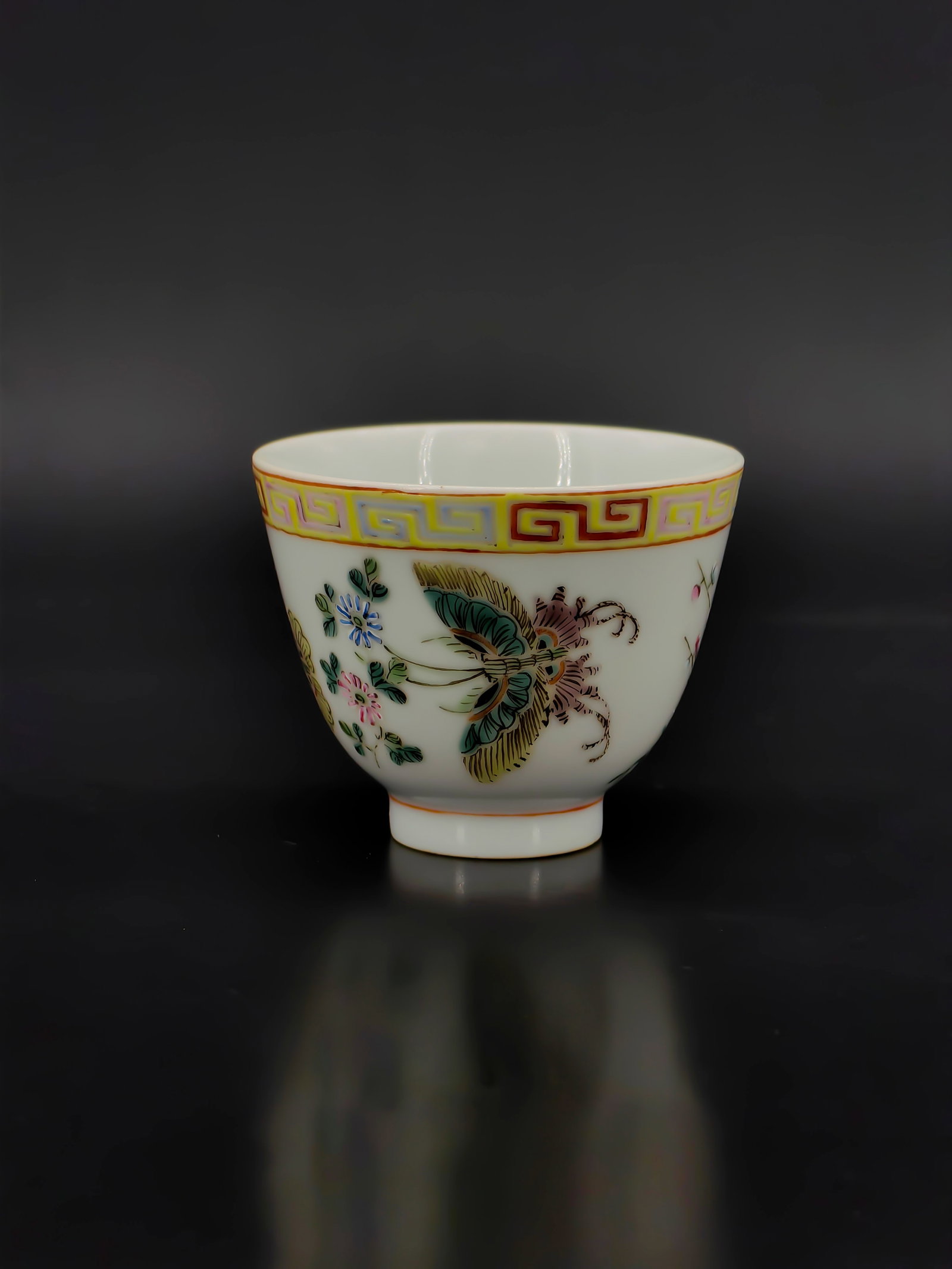 A Qing Dynasty Famille Rose Cup: This elegant "horse-hoof" shaped cup features a fine, translucent white porcelain body. The exterior is vibrantly decorated in famille rose enamels with a delicate "Butterfly and Floral" motif,