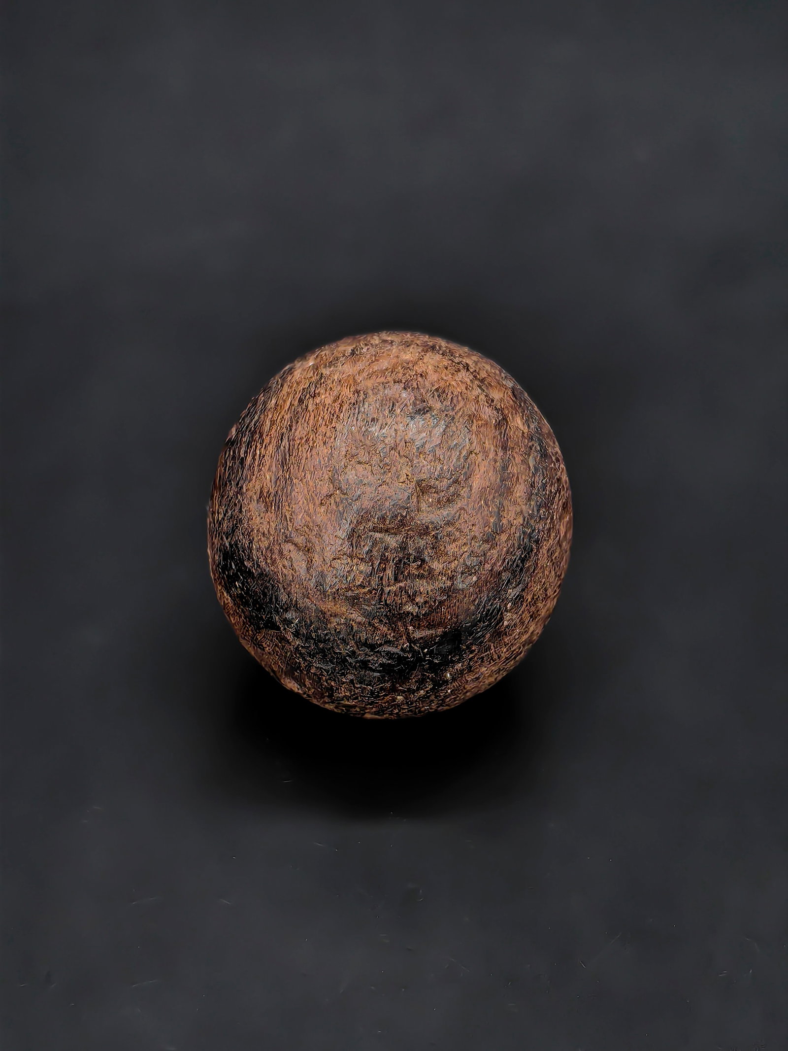 A Natural Agarwood Spheroid Specimen: This lot is a natural agarwood specimen polished into a spheroid shape. The surface is densely covered with characteristic patterns of dark brown resin streaks interwoven with lighter wood fibers,