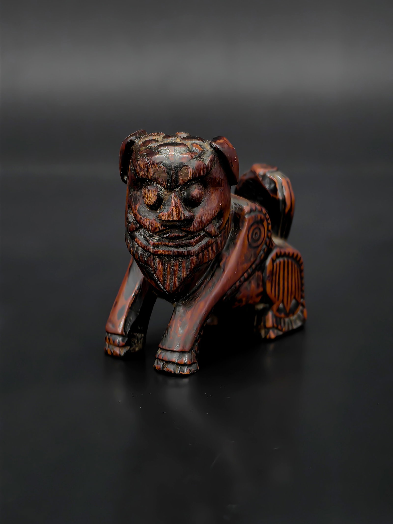 A Chinese Wooden Carving Of A Mythical Beast: This is a powerful wooden carving of a mythical beast (Pixie), standing approximately 6 cm tall. Carved from a reddish-brown hardwood with a fine grain, the piece boasts a rich, lustrous patina. The