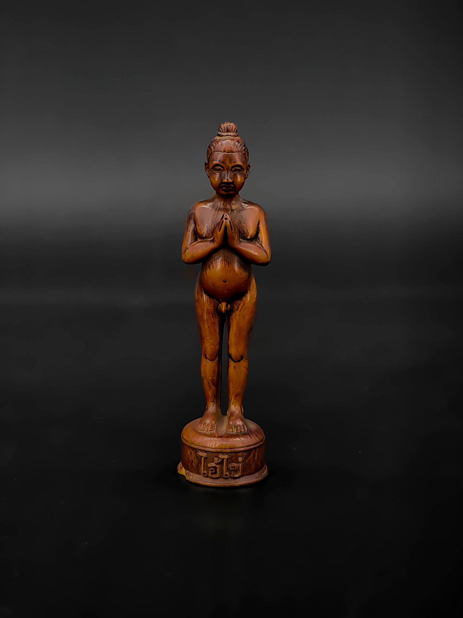 An Antique Wooden Sculpture of Thai Ai Khai: This is a wooden sculpture of Ai Khai, standing approximately 12 cm tall. Hailing from Nakhon Si Thammarat, Thailand, Ai Khai is a revered boy spirit known for bringing good fortune and fulfilling wis