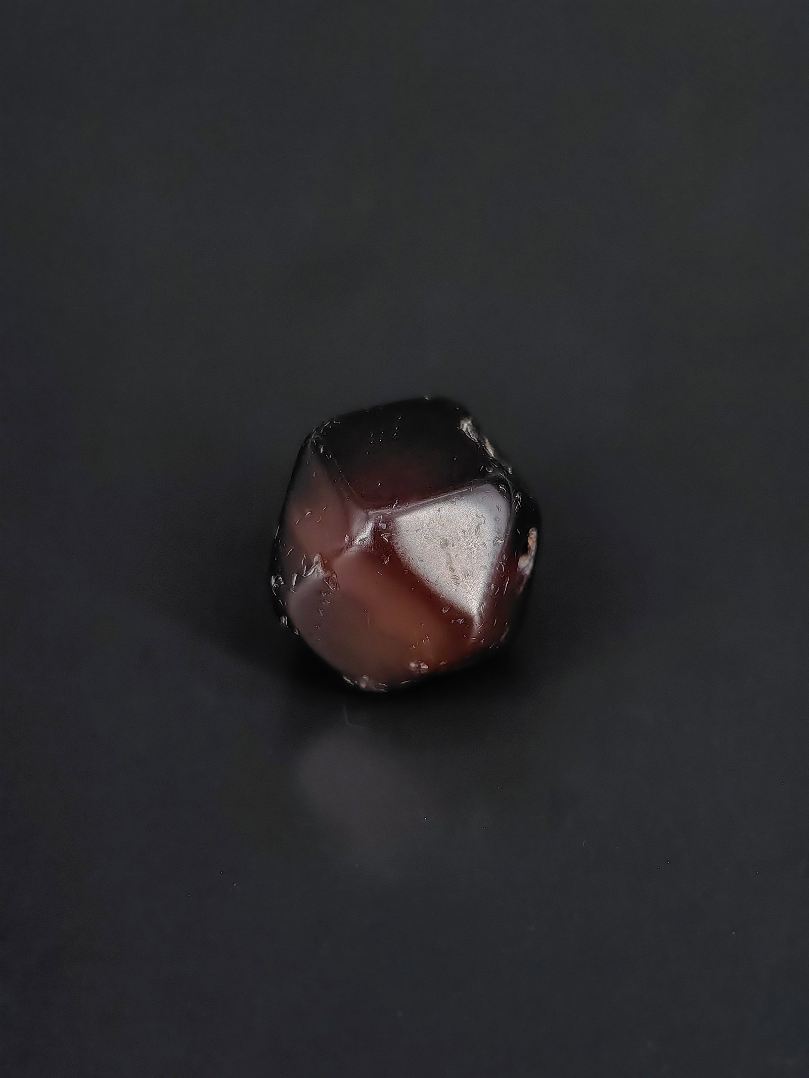 An Ancient Polyhedral Agate Bead: This is an ancient polyhedral dark-purple agate bead (commonly known as a "Vajra bead" or faceted agate bead). It features a distinctive cuboctahedral shape with multiple hand-cut facets, measuring