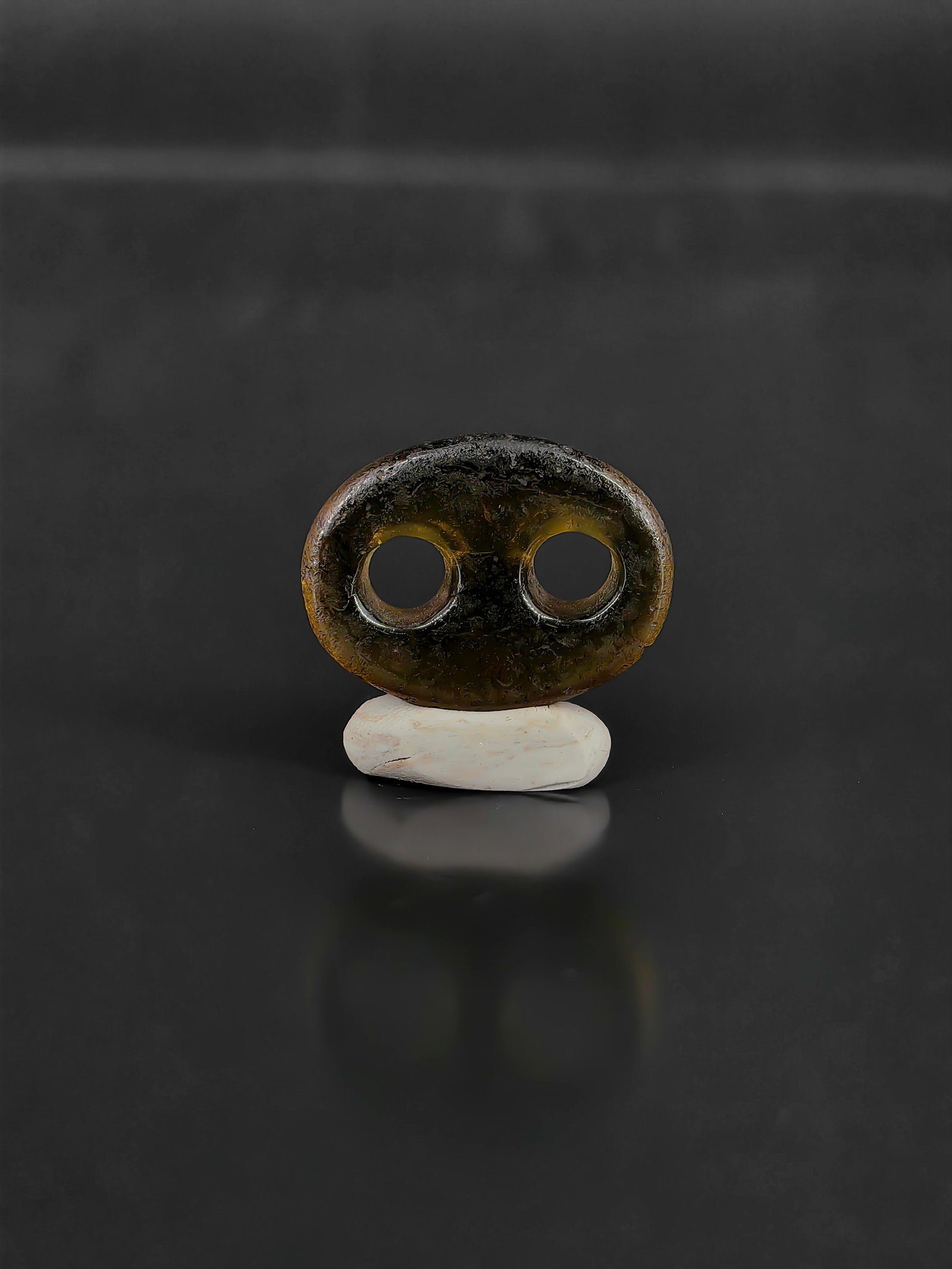 An Ancient Smoky Quartz Ornament: This artifact is an exceptionally rare ancient smoky quartz double-bore ornament, often referred to as a crystal beast-mask or dual-aperture pendant. It features a plump, oval silhouette crafted from