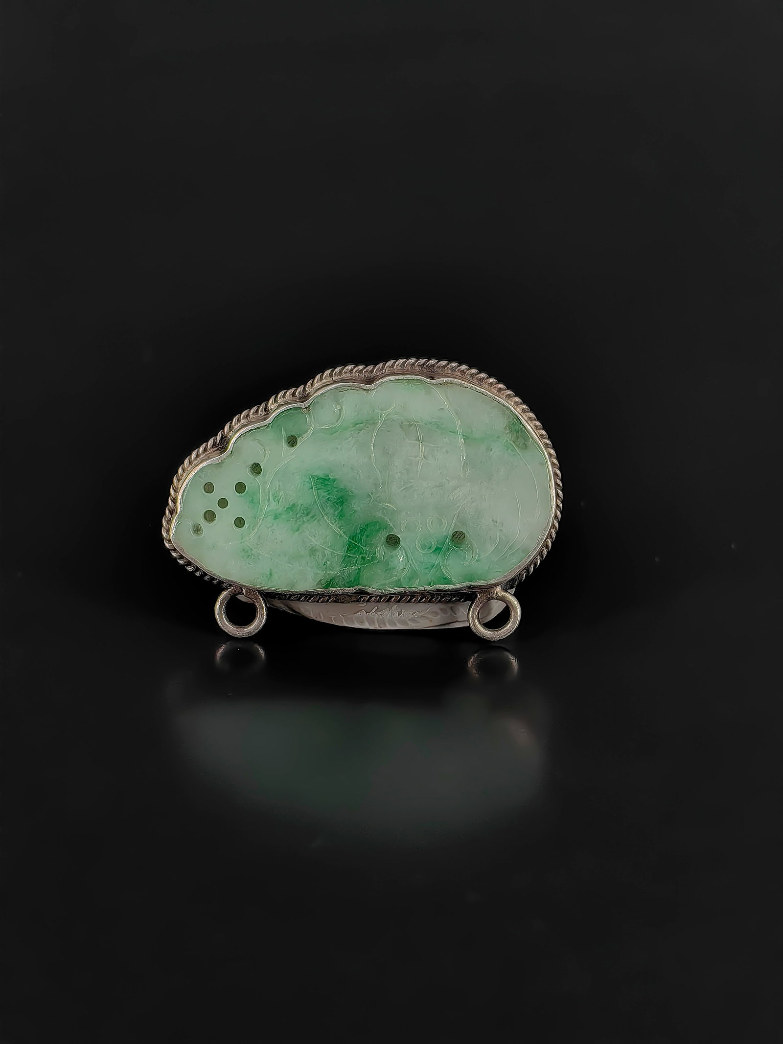 An Antique Jadeite Pendant: An exquisite Republic of China era jadeite pendant set in silver, measuring about 5cm. The front features openwork carved lotus blossoms and seedpods, symbolizing prosperity. The back is secured by
