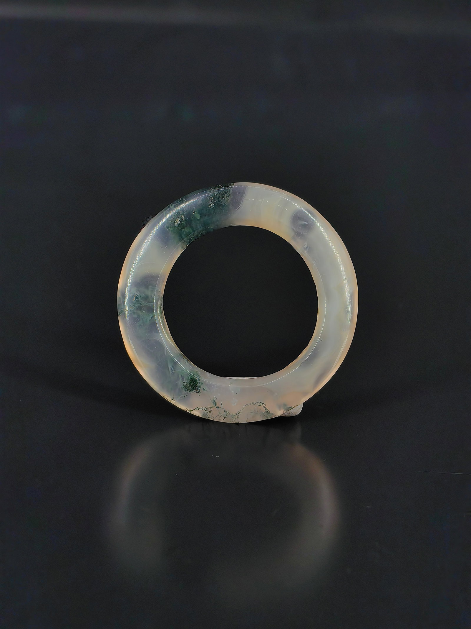 An Antique Agate Ring, Qing Dynasty: A Qing Dynasty moss agate ring. It features a translucent, icy texture with striking natural green and dark floating inclusions that resemble aquatic plants, creating a picturesque, ink-wash
