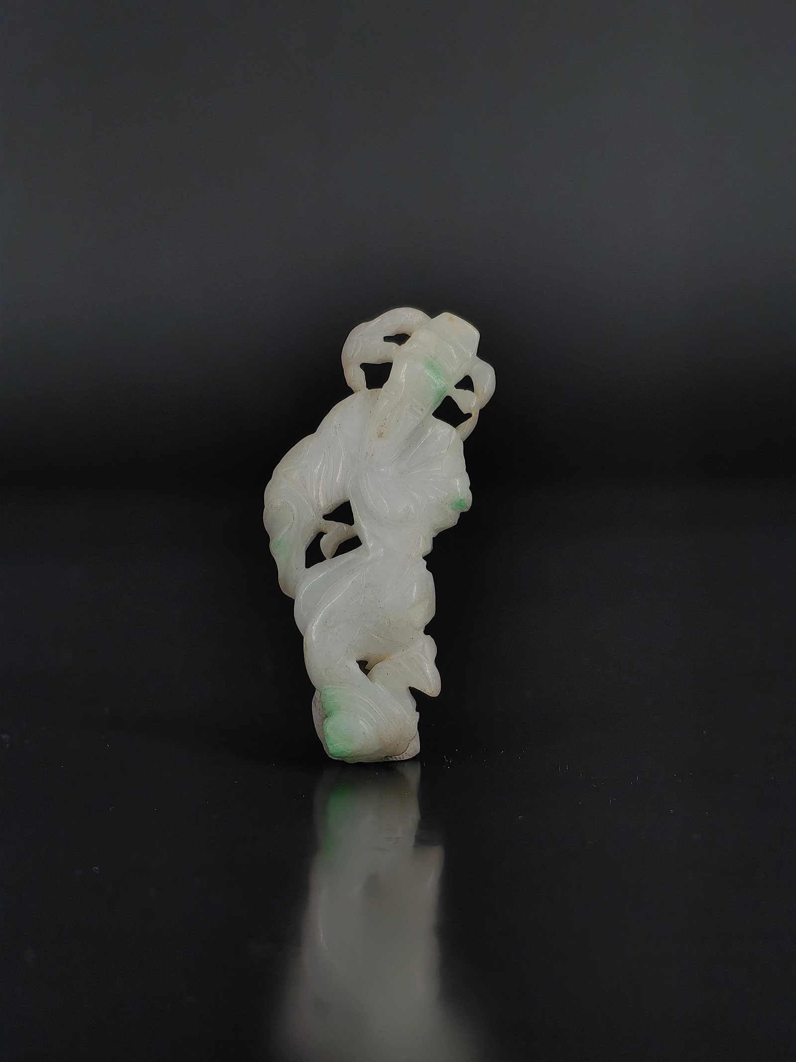An Antique Jadeite Carving,Qing Dynasty: This collection features an exquisite Qing dynasty style jadeite carving depicting an ancient Chinese civil official. Crafted from natural jadeite, the piece exhibits a translucent white jade base