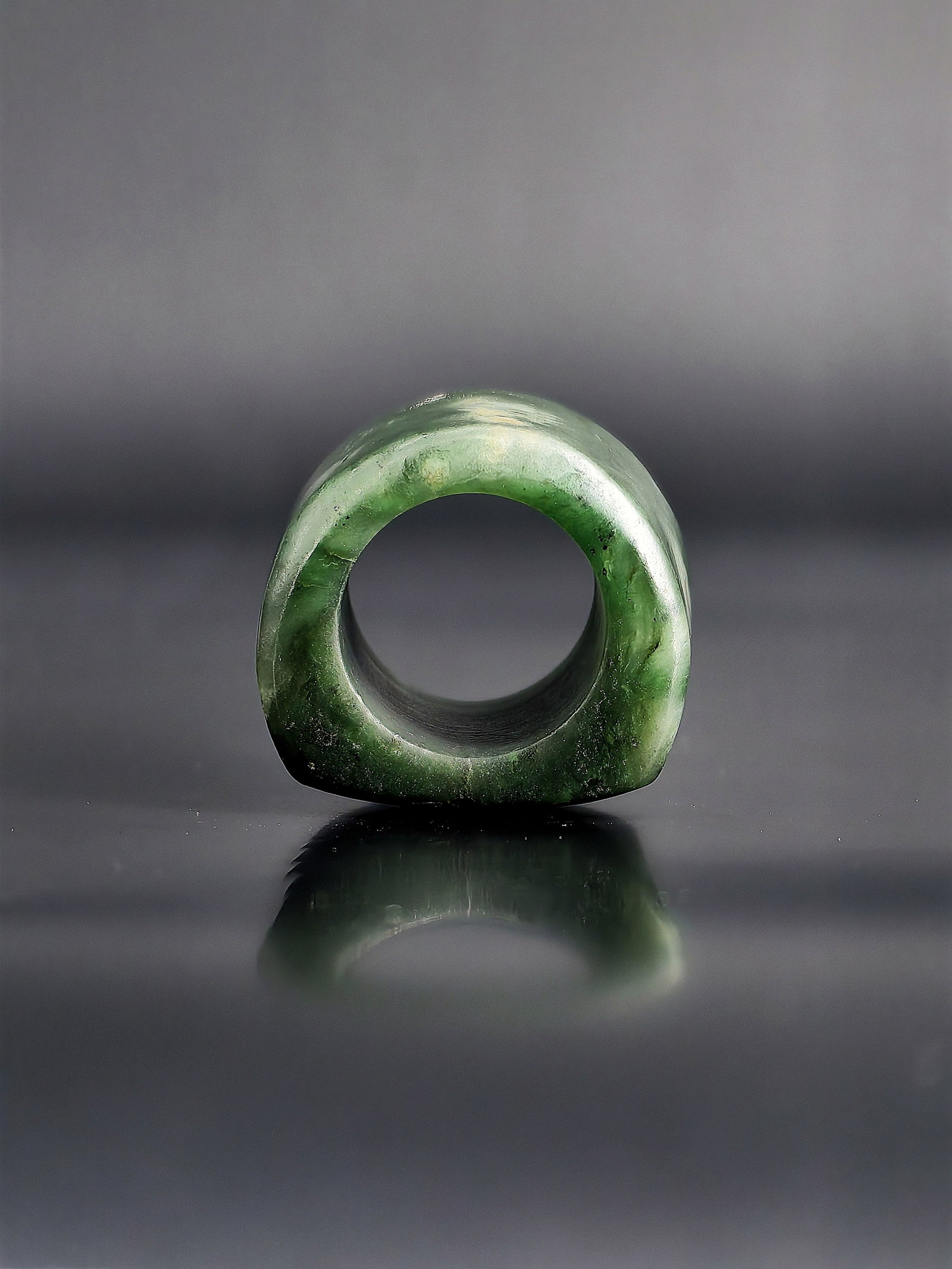 A Qing dynasty Jasper Archer's Ring: This collection features a Qing dynasty jasper archer's ring. Crafted from premium green jasper, the piece exhibits a rich, deep green hue, a warm texture, and natural black specks along with light