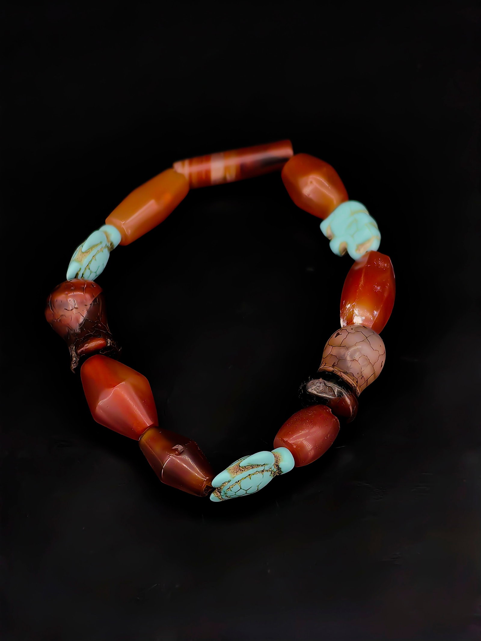 An Antique Agate Bracelet: This is an antique-style bracelet composed of South Red agate, weathered carnelian beads, and turquoise carvings, reflecting rich Himalayan cultural aesthetics.Materials: The main body features