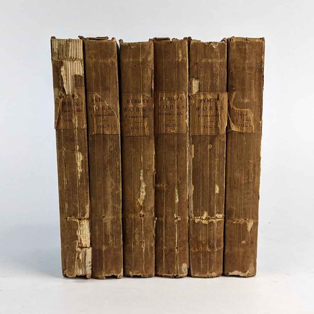 [POETRY] 1827 The Works of Lord Byron: The Works of Lord Byron in Six Volumes London: John Murray, 1827.18cm x 11cm. 6 volumes. Papered boards. Spines chipped and cracking. Occasional interior tear, fox, and soil. Fair Condition.