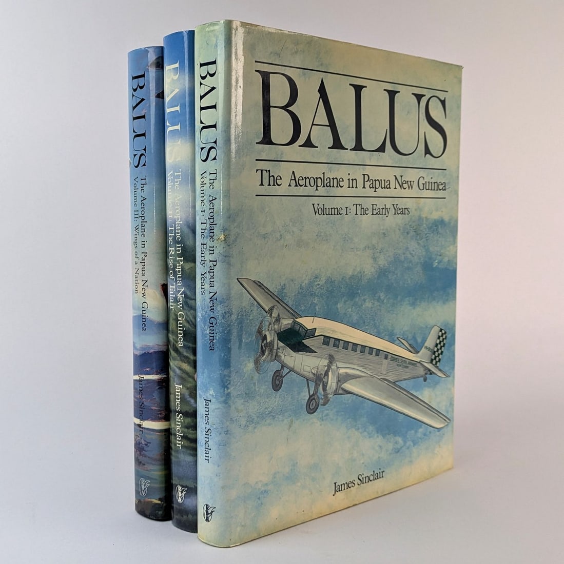 [PACIFIC, AVIATION] James Sinclair: Balus: James Sinclair Balus: The Aeroplane in Papua New Guinea Bathurst and Buranda: Robert Brown and Associates, 1986-1990.29.5cm x 21.5cm. 3 volumes, illustrations. Cloth, illustrated jackets. Minor foxin