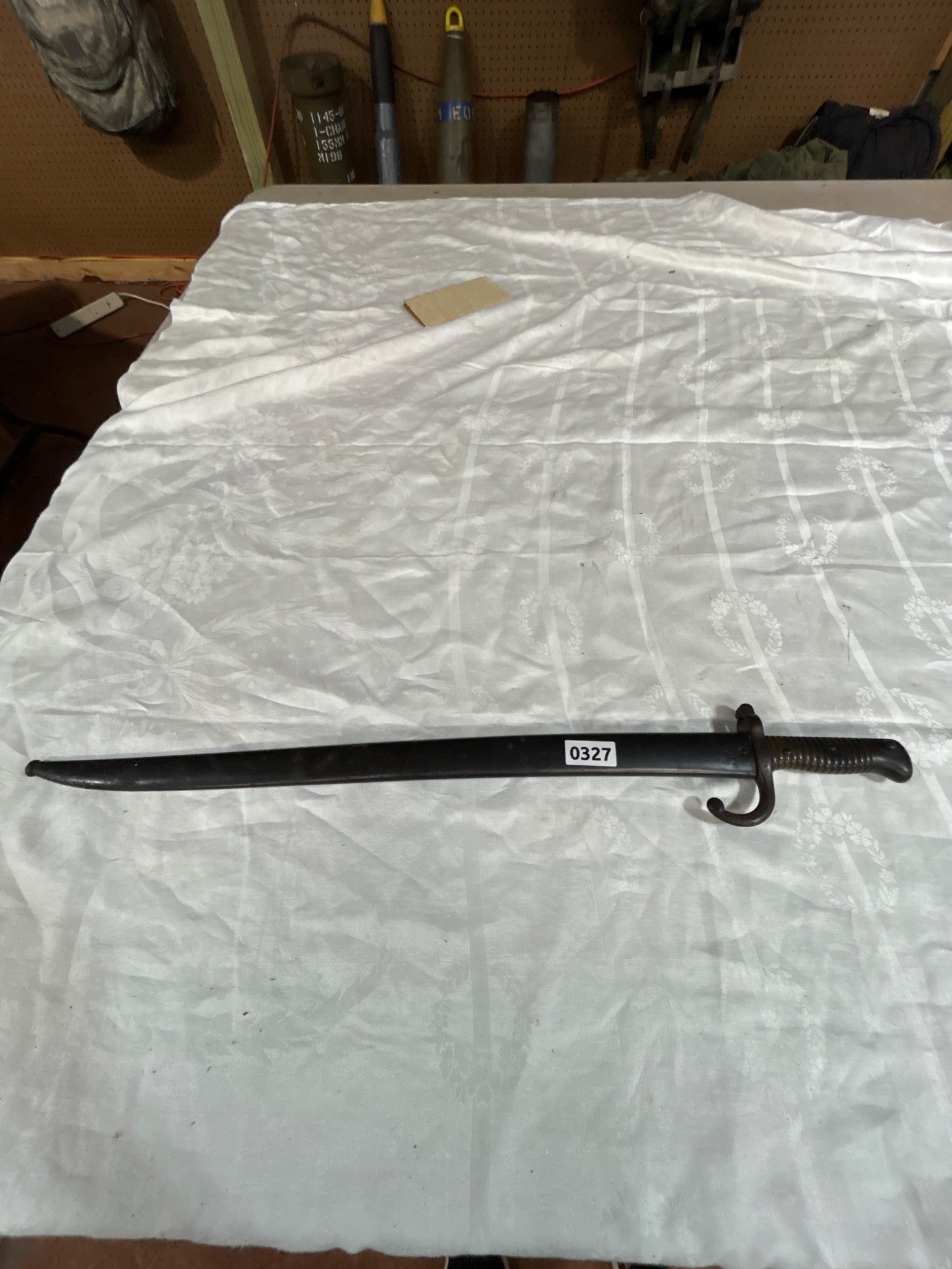 Military Bayonet with Scabbard: A bayonet with scabbard featuring a metal blade and ribbed handle. Marked with A 13685 on both blade and scabbard. Sold as is where is.The only lots that we in-house pack and ship are firearms. For al