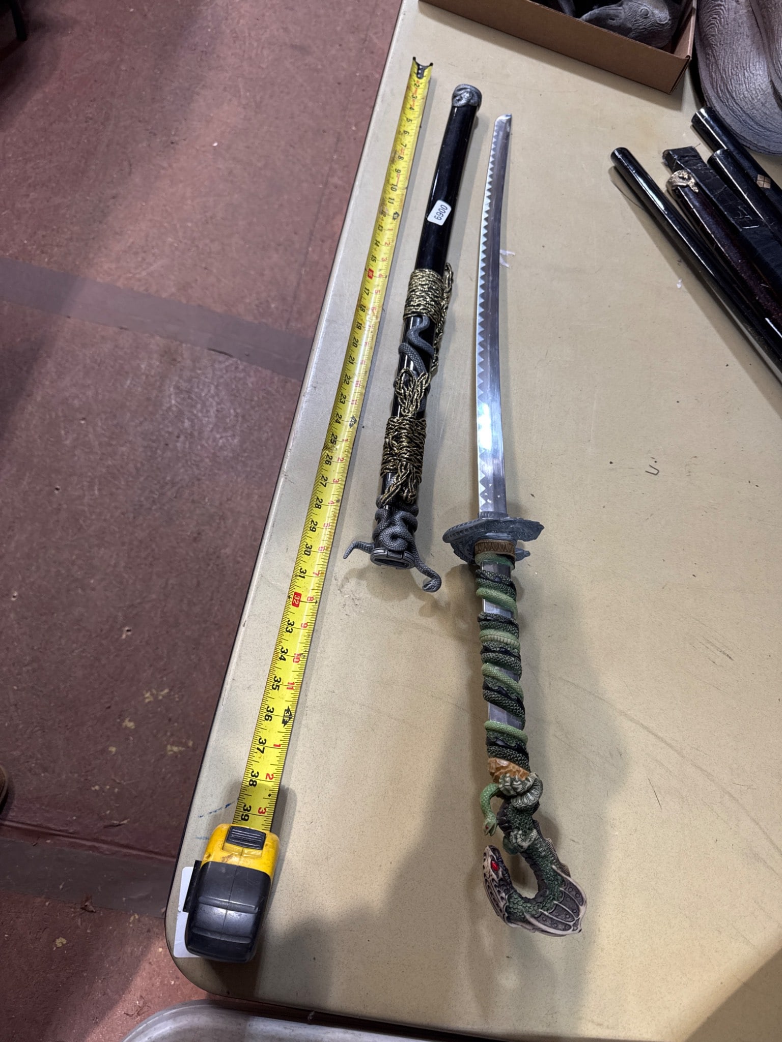 Modern Decorative Sword, 40 Inches: Modern decorative sword measuring 40 inches in length, featuring a stainless steel blade marked '440 Stainless,' a snake-themed handle with intricate designs, and a scabbard adorned with golden accent