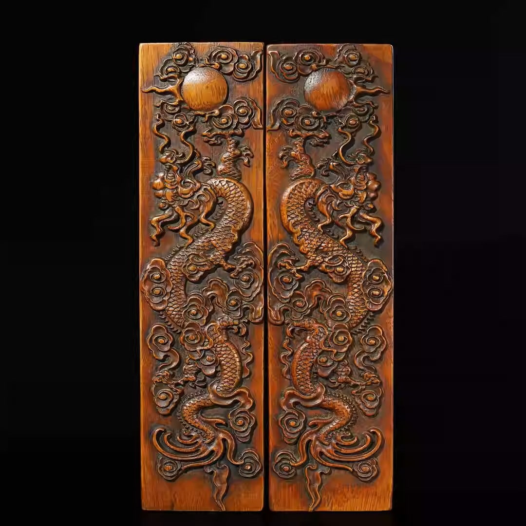A pair of rosewood carved rulers depicting dragons playing with a pearl: Each piece Length 26cm, width 7cm, thickness 2.7cm, total weight 730g