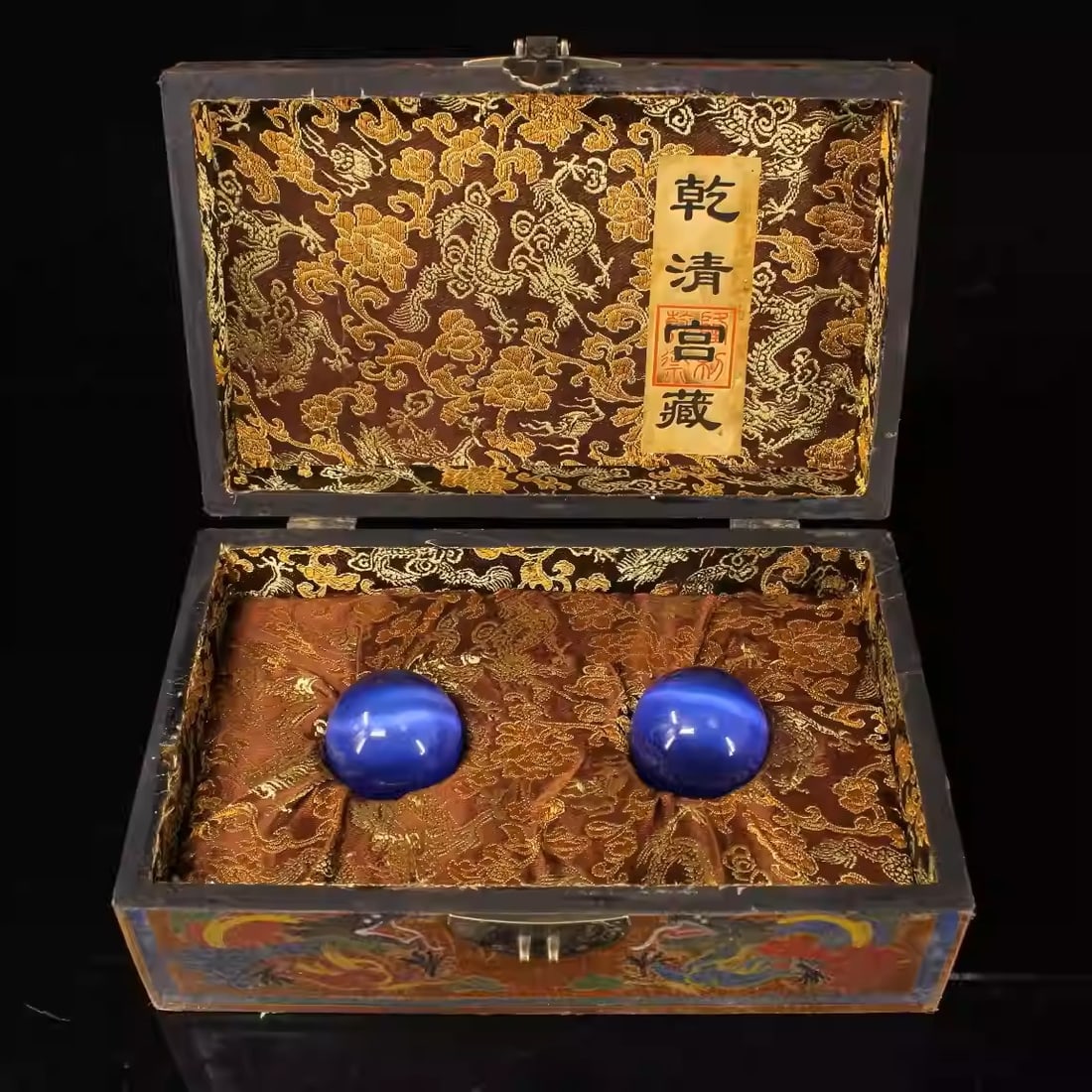 A pair of precious blue cat's eye stones with an antique lacquer box: Each Ball Dimensions: Diameter 5cm, Weight: 146g ? Box Dimensions: Length 26cm, Width 16.5cm, Weight: 1104g