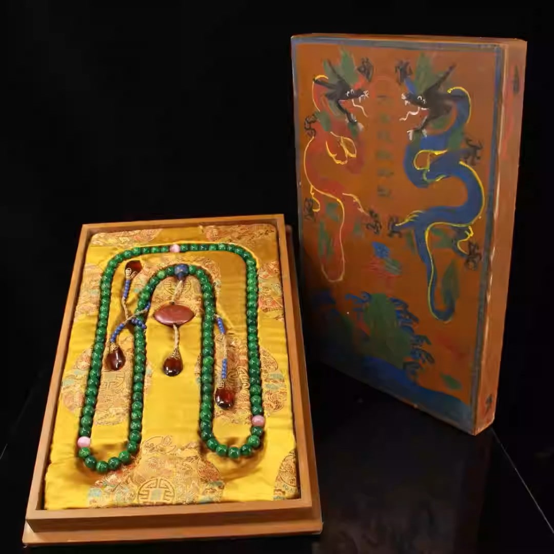 A Qing Dynasty imperial jade court necklace with a lacquer box: Dimensions: The box is 44 cm long and 30.5 cm wide, the beads are 1.4 cm in diameter, and the set weighs 2735 grams.