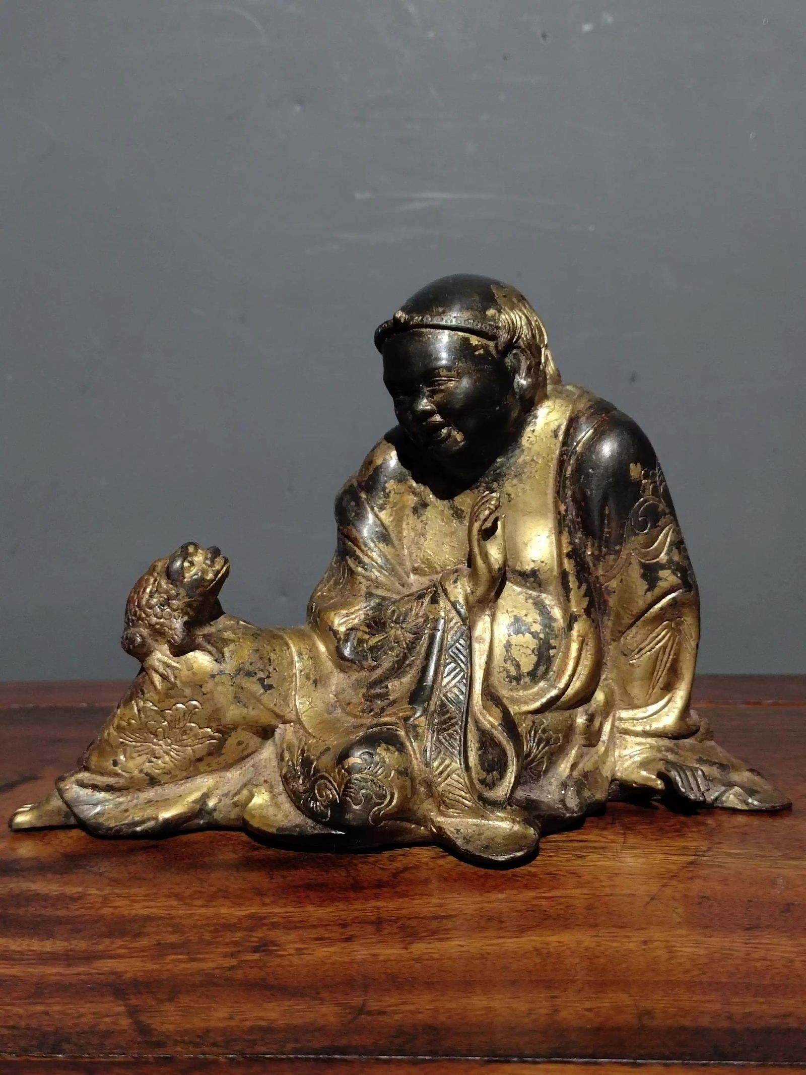 A pure copper, gilded, and cinnabar-painted Buddha statue depicting Liu Hai playing with a golden: Dimensions: Length 18cm, Width 10.5cm, Height 12.5cm Weight: 1230g