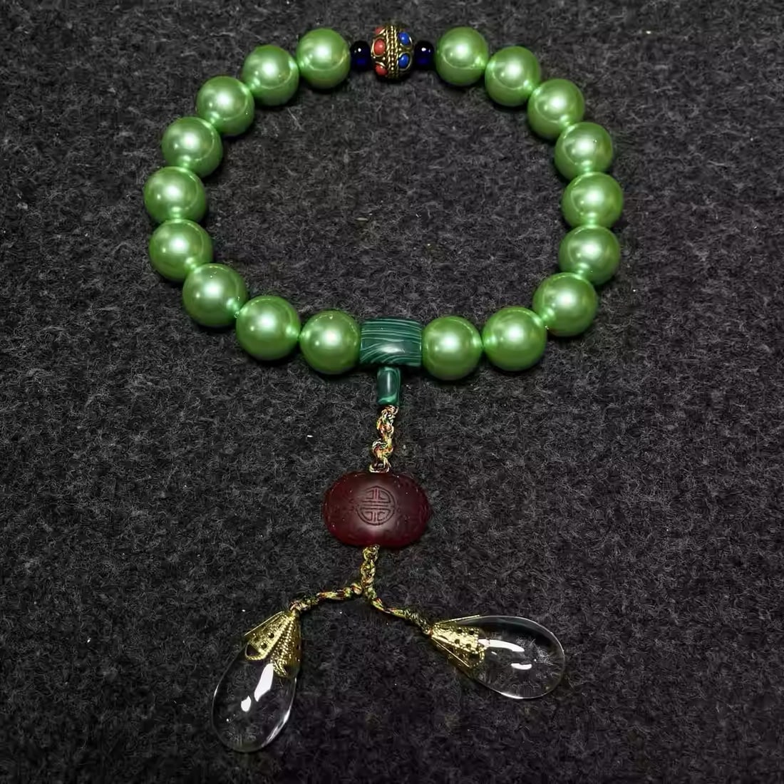 A rosewood box inlaid with mother-of-pearl contains a treasured eighteen-bead hand-held pearl: Pearl Dimensions: Diameter 20mm; Box Dimensions: Length 20cm, Width 13cm, Height 7cm