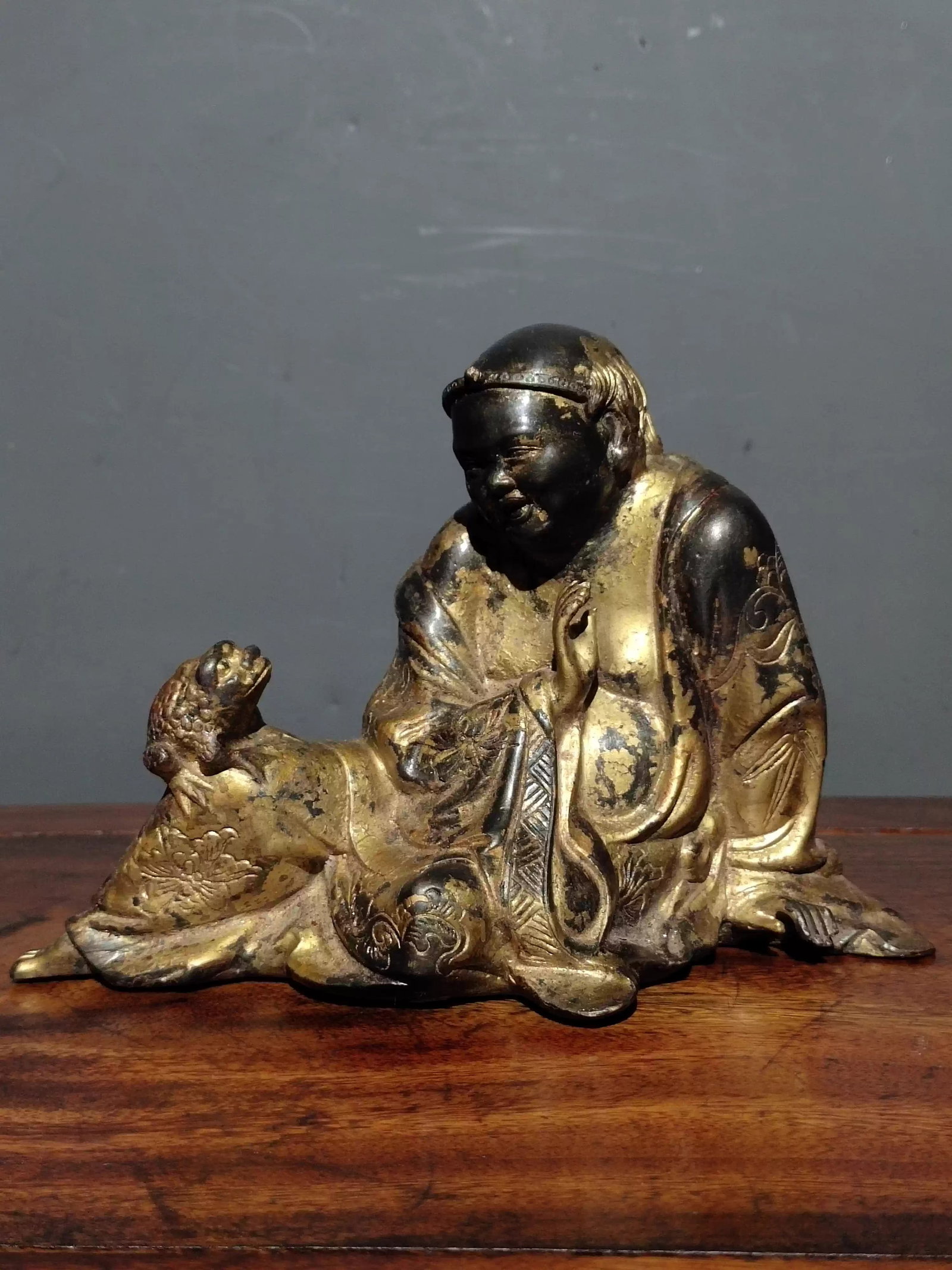 A pure copper, gilded, and cinnabar-painted Buddha statue depicting Liu Hai playing with a golden: Dimensions: Length 18cm, Width 10.5cm, Height 12.5cm Weight: 1230g