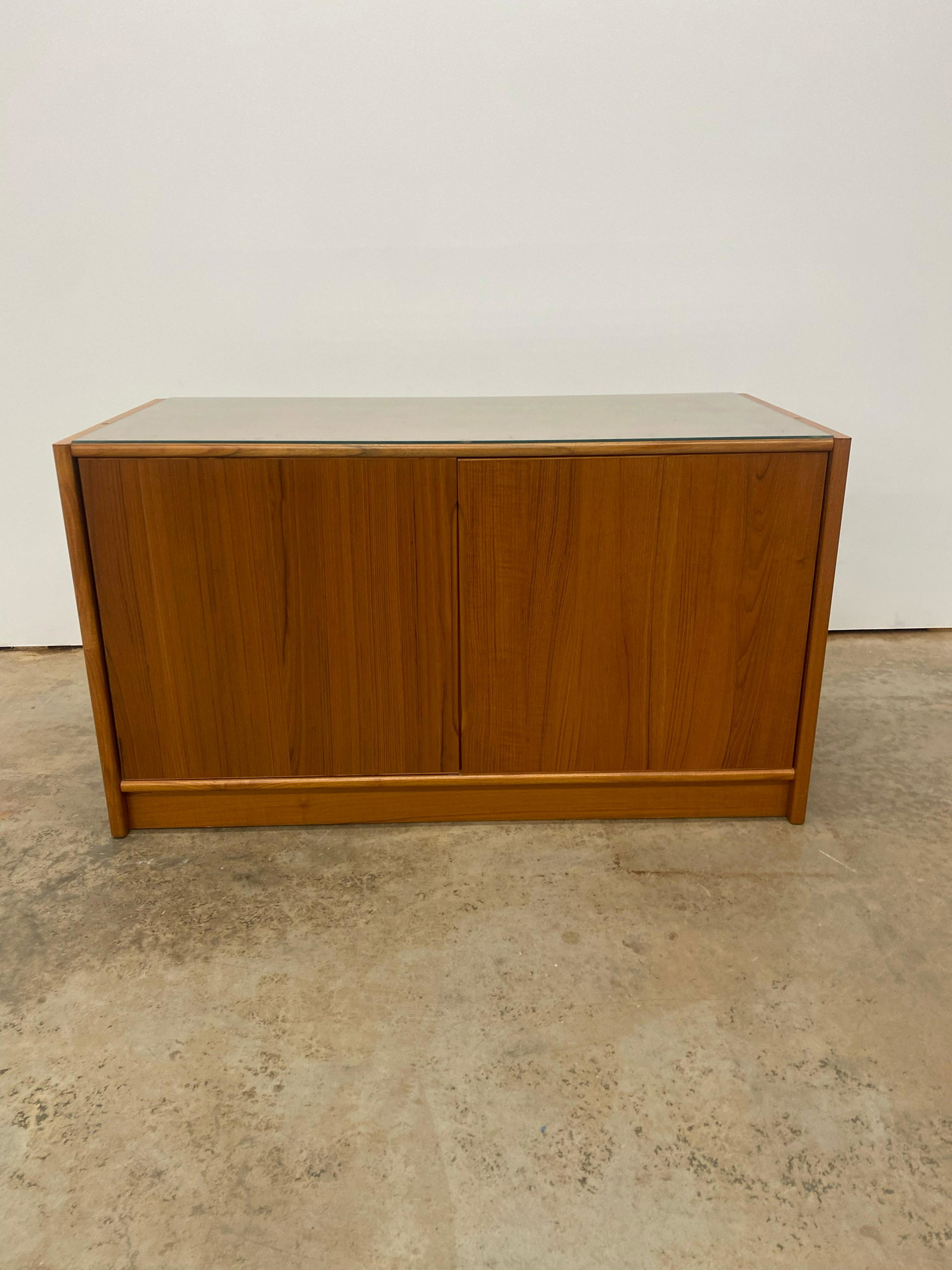 Teak Credenza: Small Danish teak credenza. 2 shelves behind doors. Comes with glass top.