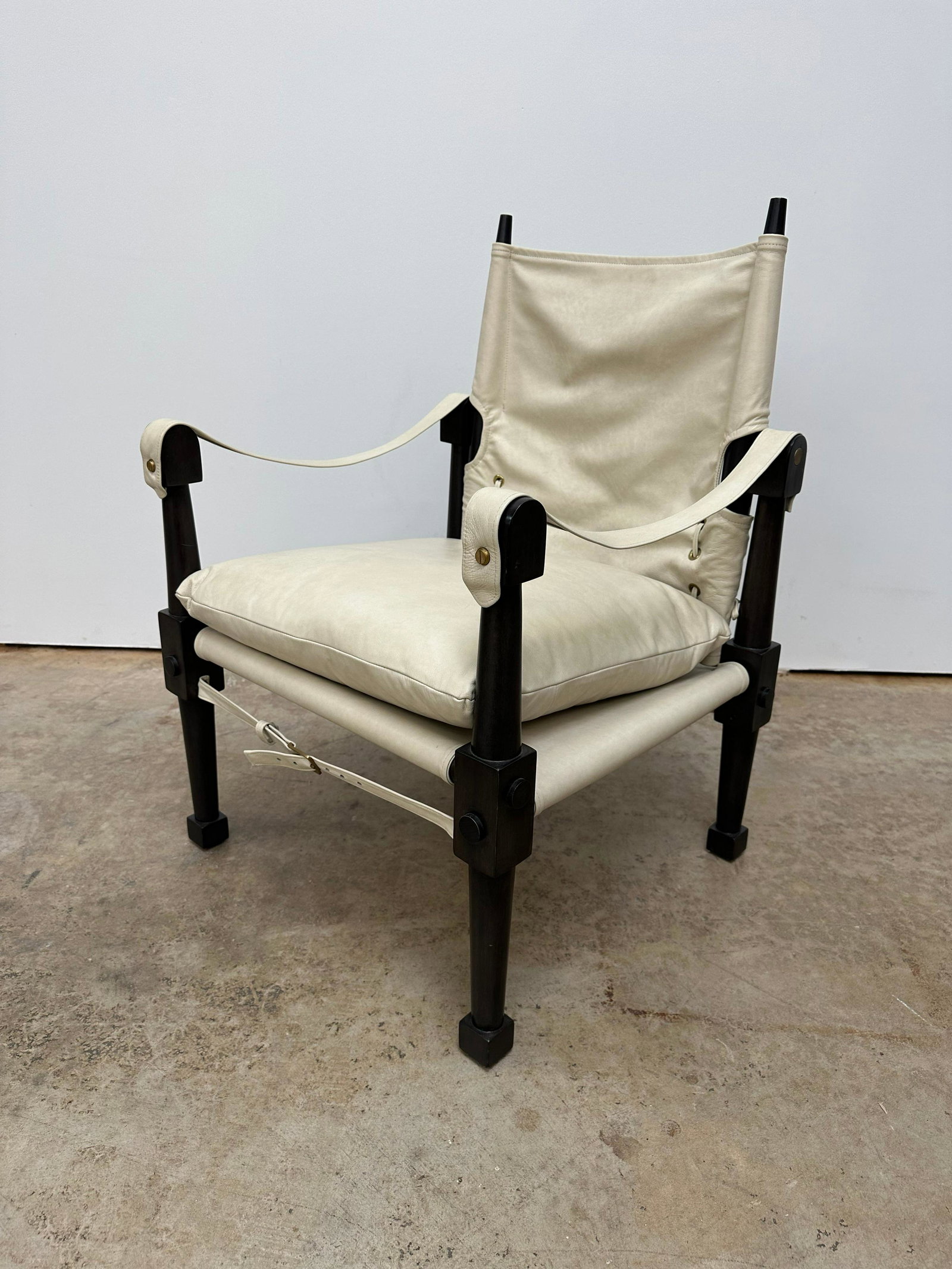 Vintage Leather Safari Chair: Leather safari chair by Chaddock Furniture. Chantilly off white leather and charcoal finish wood. Seat back can pivot to adjust angle of backrest. Seat height: 18 inches.