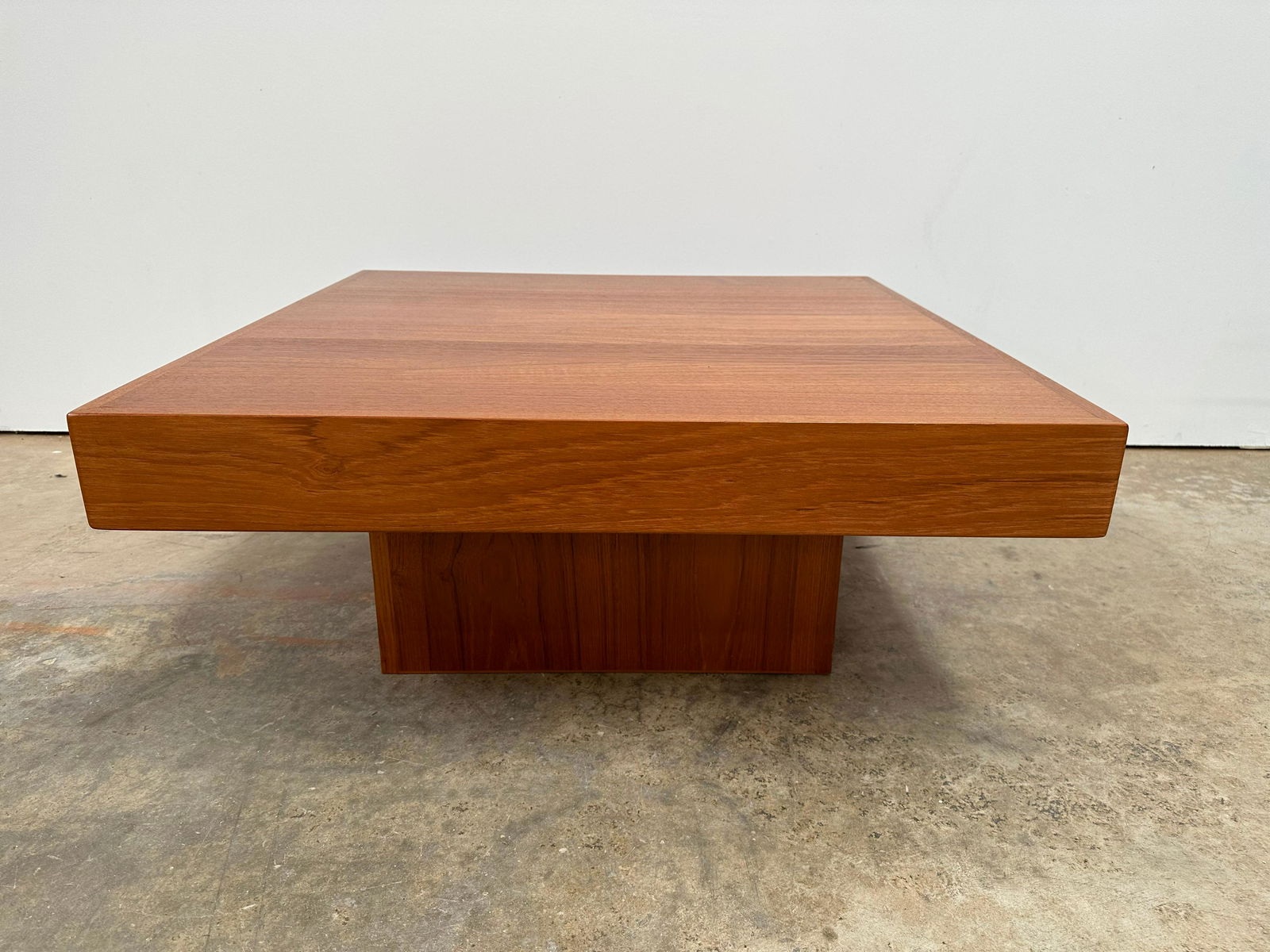 Teak Coffee Table: Teak coffee table. Table sits on a plinth base. Nice wood grain.