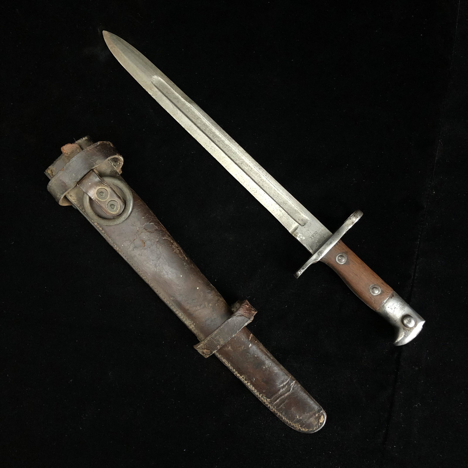 US Model 1892 Krag Bayonet dated 1902, Leather Scabbard: Spanish American war era 1892 US krag jorgensen bayonet with original cavalry picket pin leather scabbard. Bayonet is marked US and 1902. Locking pin working. Wood grips solid. Blade has been mildly s