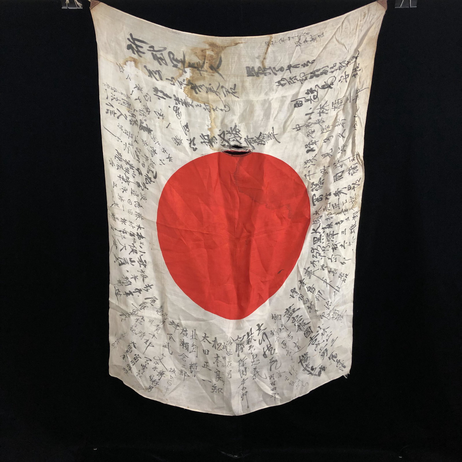 WWII Silk Signed Japanese Good Luck Meatball Flag: WWII Japanese silk good luck signed flag. Small tear and water stain. Otherwise in good condition, measures 36"x 26" inches. Lots of signatures. Leather corner straps and string in good shape.