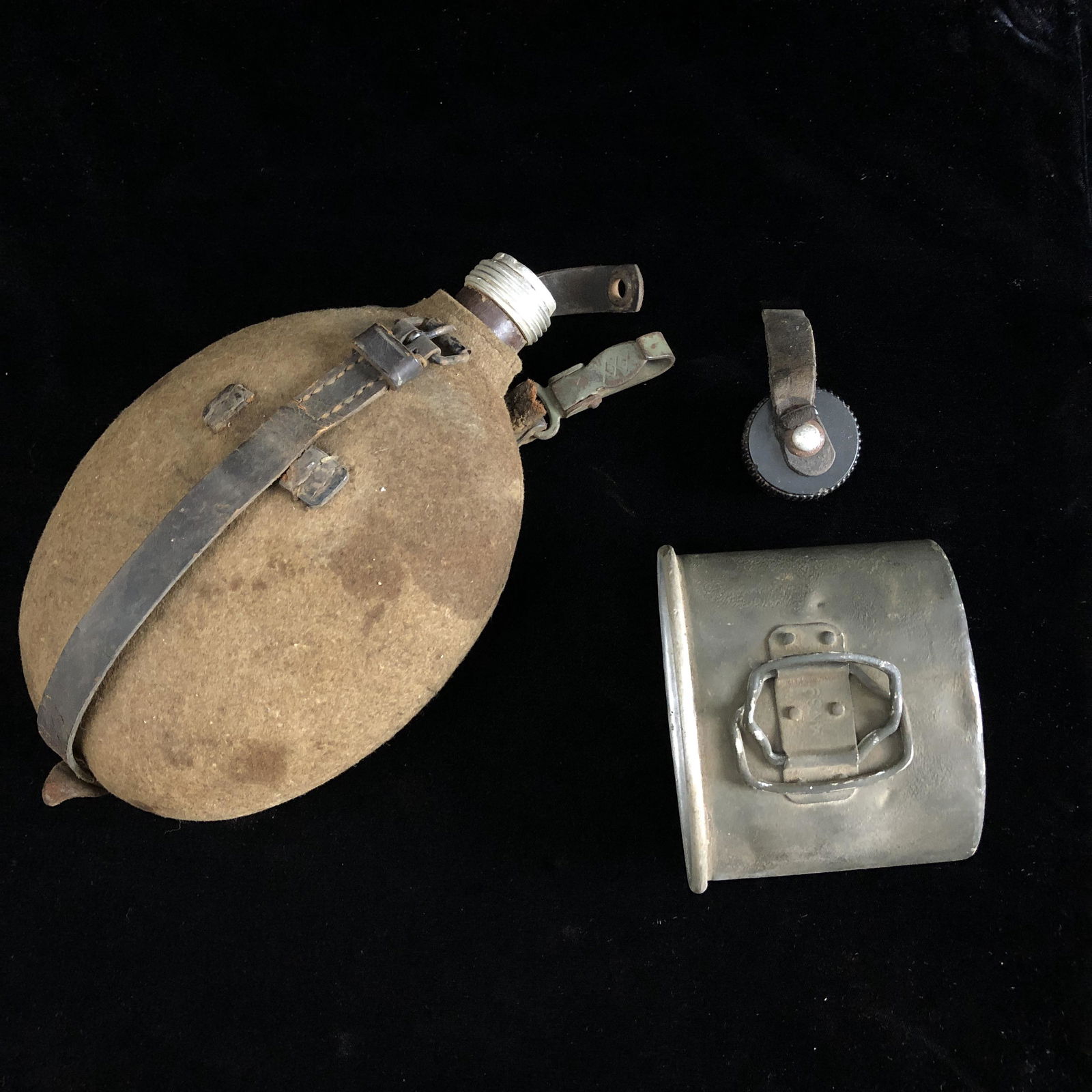 WWII M31 German Army Soldier Canteen: WWII M31 German canteen with aluminum cup, period painted green camo, and wool canteen cover. Leather strap broken. Some staining. Cap retains original leather washer. Came from a local New Orleans Es