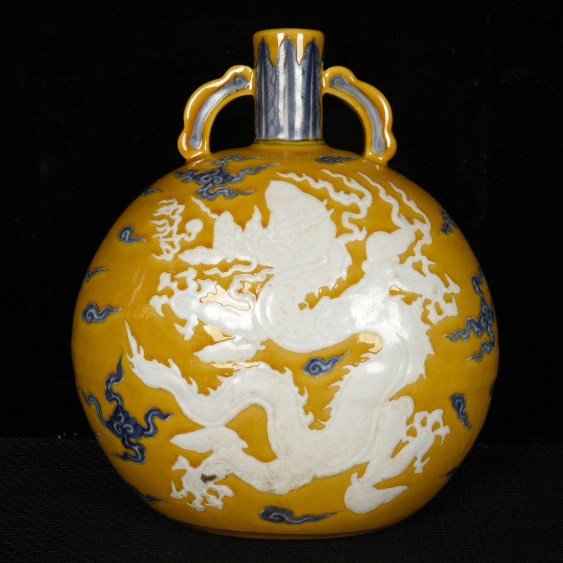 Ming Xuande yellow ground blue and white carved amphora with white clouds and dragon pattern: Ming Xuande yellow ground blue and white carved amphora with white clouds and dragon patternSpecifications: 25.5cmX22cmX14cm