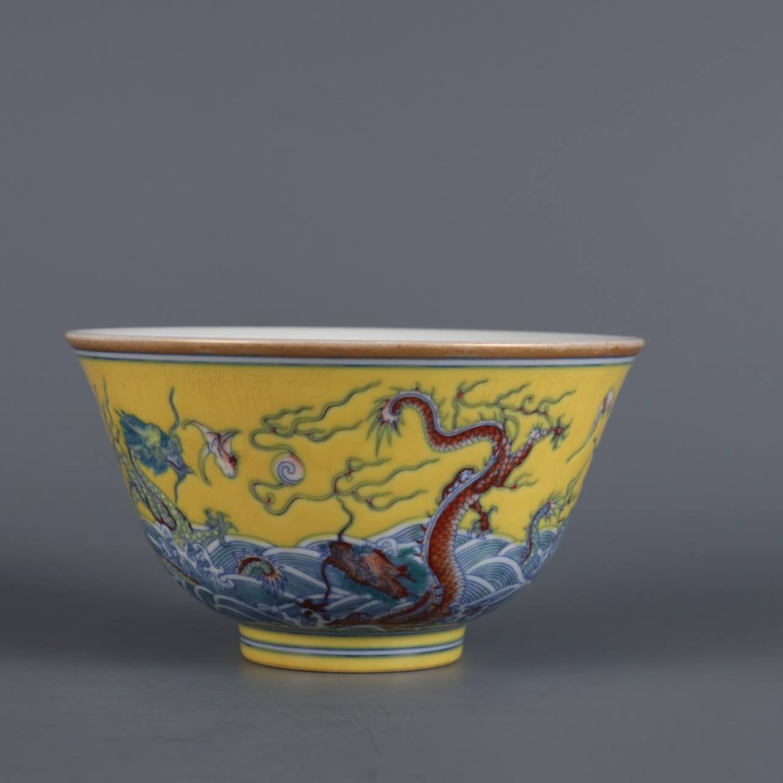 Qing Dynasty Guangxu year yellow ground bowl with colorful sea water: Qing Dynasty Guangxu year yellow ground bowl with colorful sea water, clouds and dragon pattern. Size: height 6cm, diameter 10.5cm