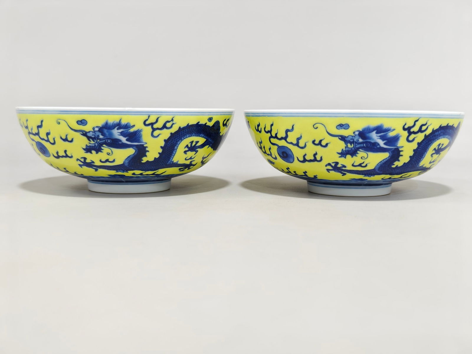 A bowl with a flat foot and a blue and white yellow background with a double dragon playing with a: 5.5 cm high and 14.3 cm in diameter.