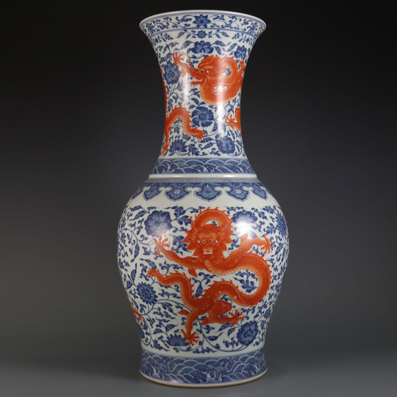 A large blue-and-white porcelain vase with an overglaze red lotus scroll and five dragons design,: Height 61 cm, Belly diameter 28 cm, Mouth diameter 22.5 cm.