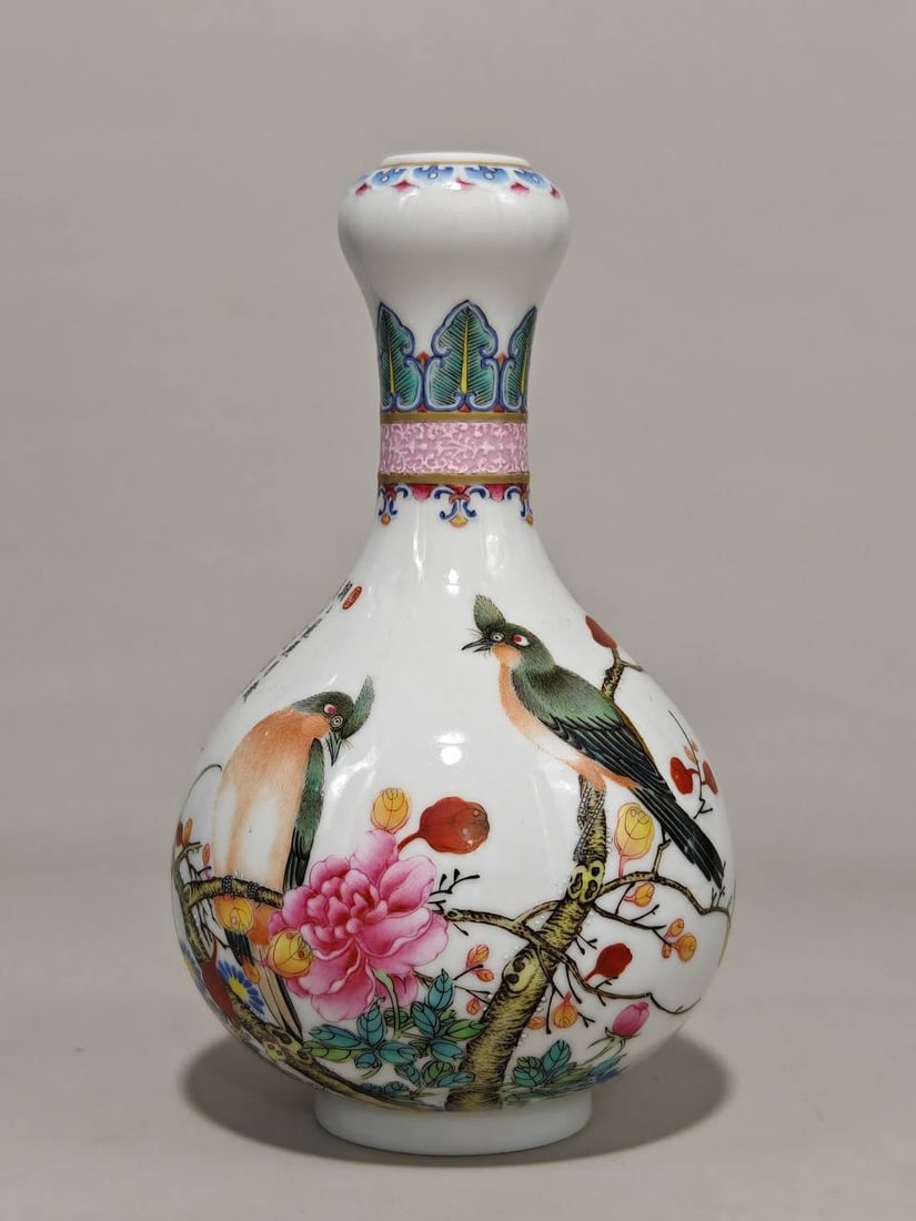 A famille rose garlic-shaped vase with floral and bird design: A famille rose garlic-shaped vase with floral and bird design, bearing the mark of the Qianlong period of the Qing Dynasty. It measures 17 cm in height and 11 cm in diameter.