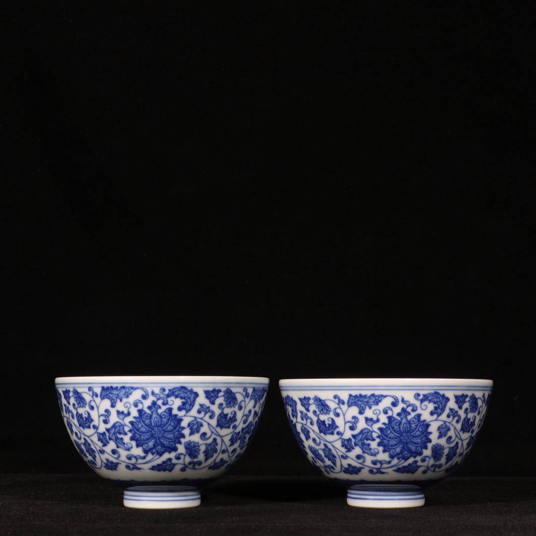 A pair of blue and white porcelain cups with a scrolling floral design: A pair of blue and white porcelain cups with a scrolling floral design from the Qianlong period of the Qing dynasty. Dimensions: Height 5.2 cm, Diameter 9 cm