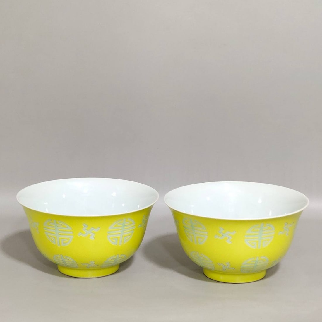 A Qing Dynasty Yongzheng period yellow-ground green-enamel longevity pattern tea bowls: A Qing Dynasty Yongzheng period yellow-ground green-enamel longevity pattern tea bowls 5.9 cm high and 10.7 cm in diameter,