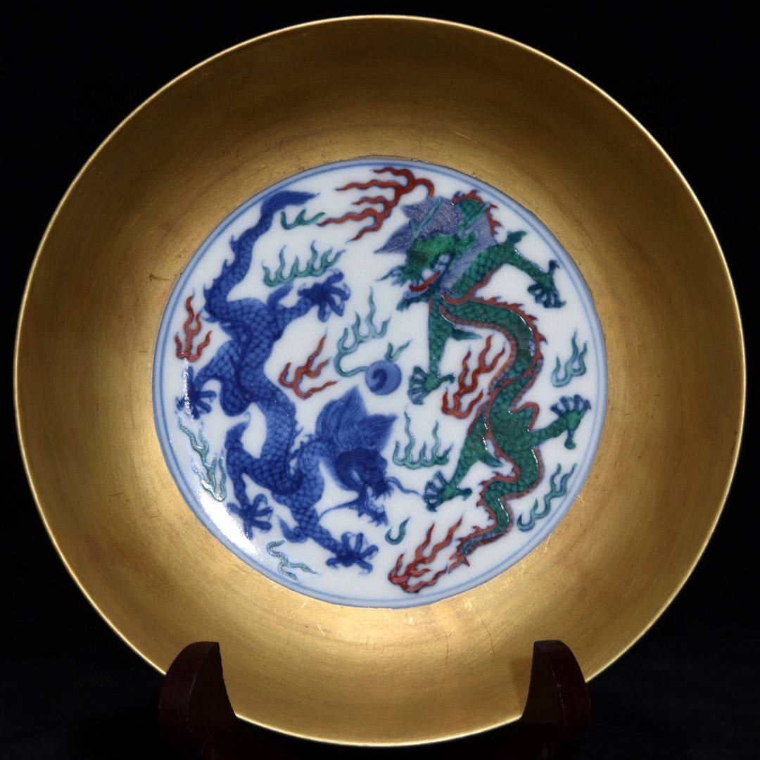 A Qing Dynasty, Yongzheng period, doucai (enamel overglaze) gilt-gilt plate: A Qing Dynasty, Yongzheng period, doucai (enamel overglaze) gilt-gilt plate with a design of two dragons playing with a pearl, 3.5cm high and 14.9cm in diameter.
