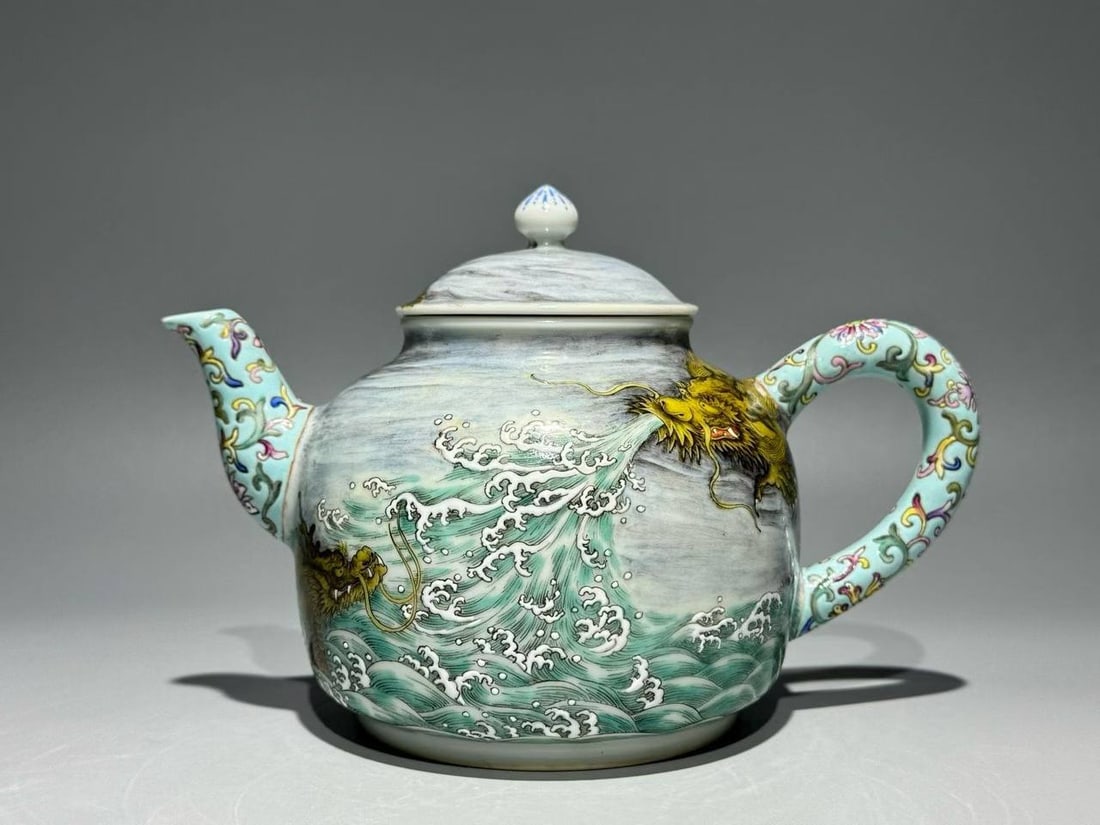 A Qing Dynasty Qianlong period famille rose turquoise teapot with a dragon and son scroll design: A Qing Dynasty Qianlong period famille rose turquoise teapot with a dragon and son scroll design. Width: 19cm, Height: 12.8cm
