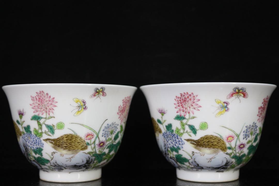 A pair of Qianlong famille rose cups with floral and bird design depicting a peaceful and prosperous: A pair of Qianlong famille rose cups with floral and bird design depicting a peaceful and prosperous life. 9 cm wide, 6 cm high.