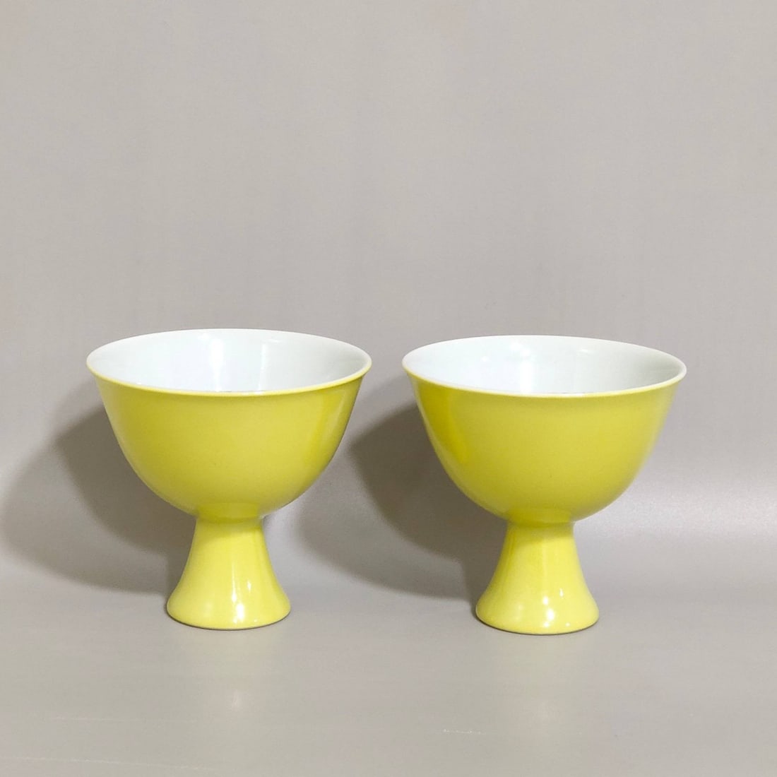 A Qing Dynasty Yongzheng period lemon-yellow glazed stem cups: A Qing Dynasty Yongzheng period lemon-yellow glazed stem cup decorated with lotus flowers and kingfishers, measuring 5.4 cm in height and 5.6 cm in diameter at the mouth.