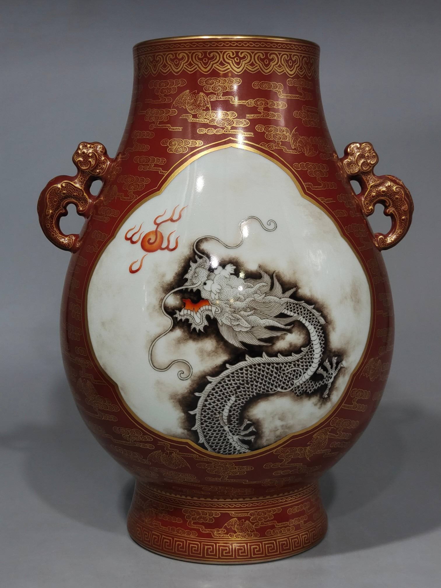 A Qing Dynasty Yongzheng period famille rose enameled bamboo tube with a cloud and bat design: A Qing Dynasty Yongzheng period famille rose enameled bamboo tube with a cloud and bat design, decorated with gold leaf and depicting clouds and bats, featuring two dragons playing with a pearl. It me