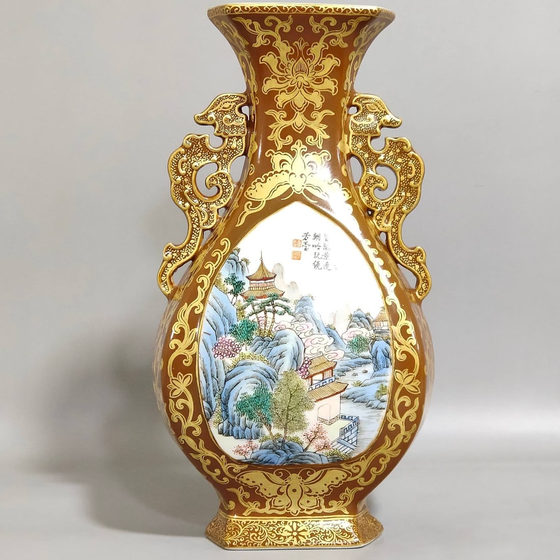 A Qing Dynasty Qianlong period hexagonal vase with a purple-gold glaze and gilt-painted landscape: A Qing Dynasty Qianlong period hexagonal vase with a purple-gold glaze and gilt-painted landscape design, measuring 20.8 cm in height and 11 cm in diameter.