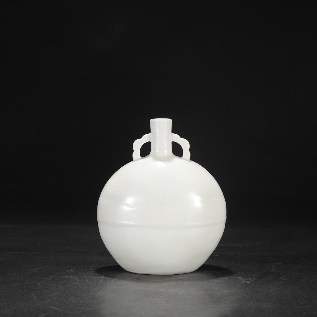 A Ming Dynasty Yongle period sweet white glazed moon flask with incised "Three Abundances" design.: Dimensions: Height 27.5 cm, Mouth diameter 3 cm, Belly diameter 21 cm.