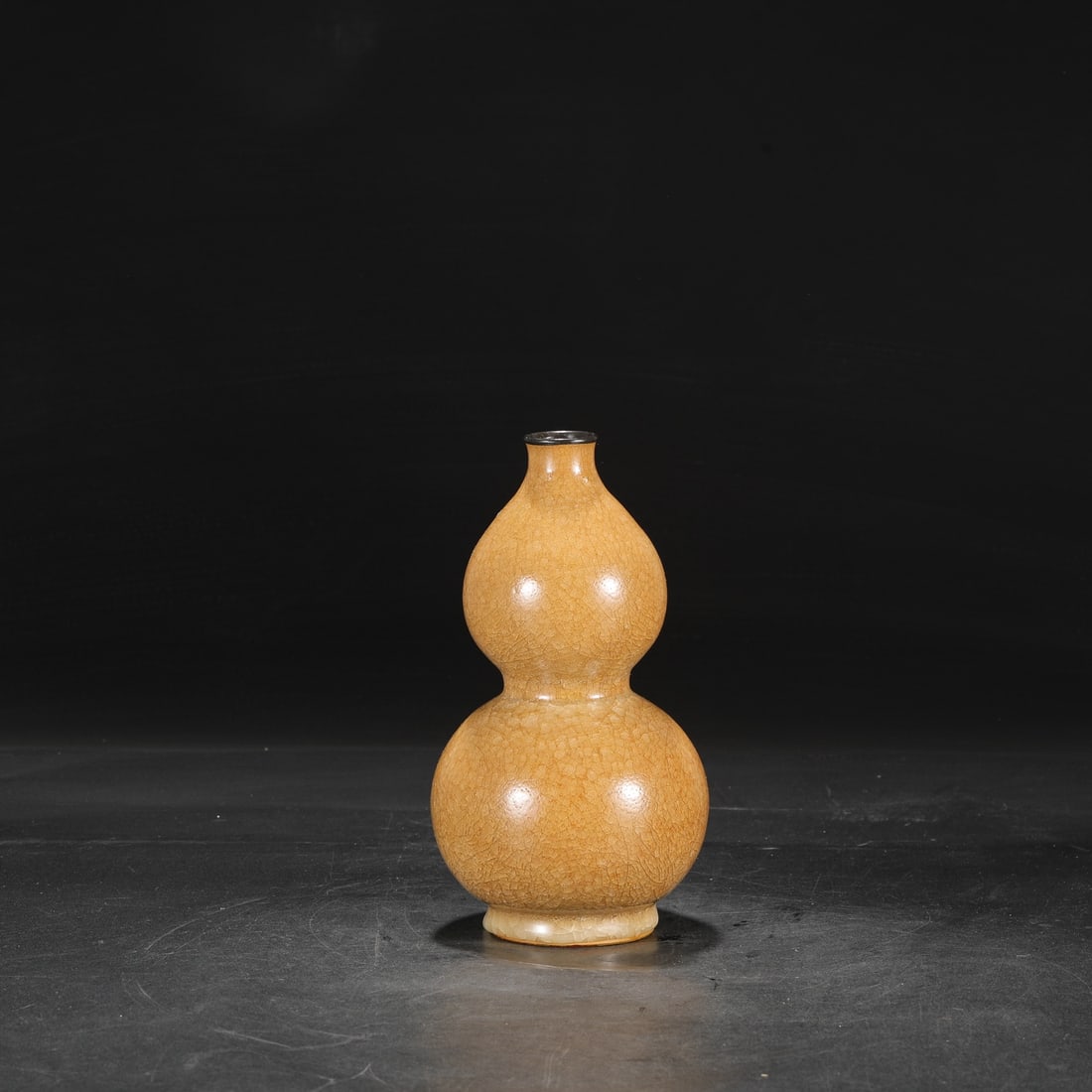 A large gourd-shaped vase with a pale yellow glaze, ice-crack pattern, and silver rim, formerly in: Dimensions: Height 23.5 cm, Mouth diameter 3 cm, Belly diameter 12 cm.