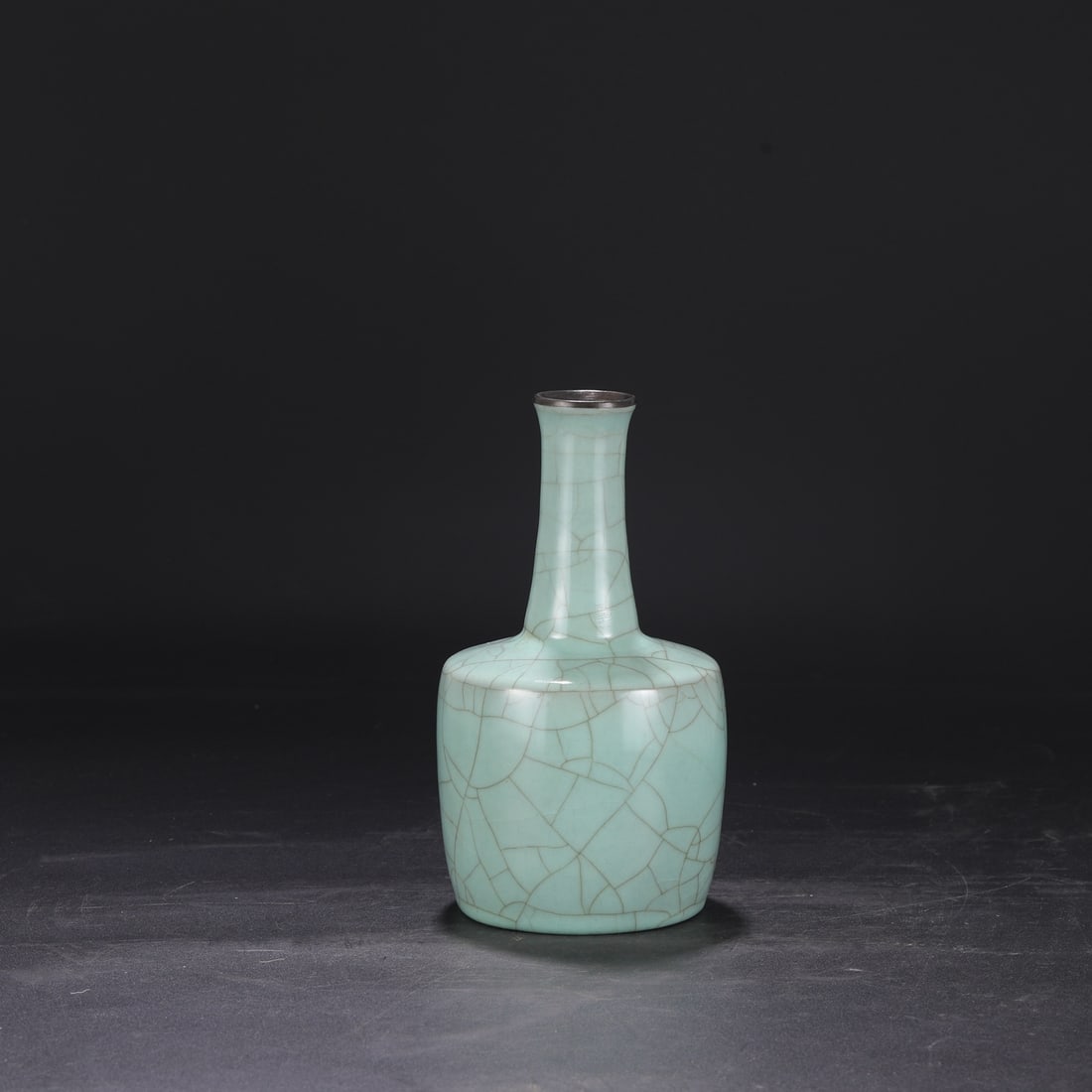 A Southern Song Dynasty official kiln celadon vase with a silver rim, used in the imperial court,: Dimensions: Height 22.5 cm, Mouth diameter 4 cm, Belly diameter 12 cm.
