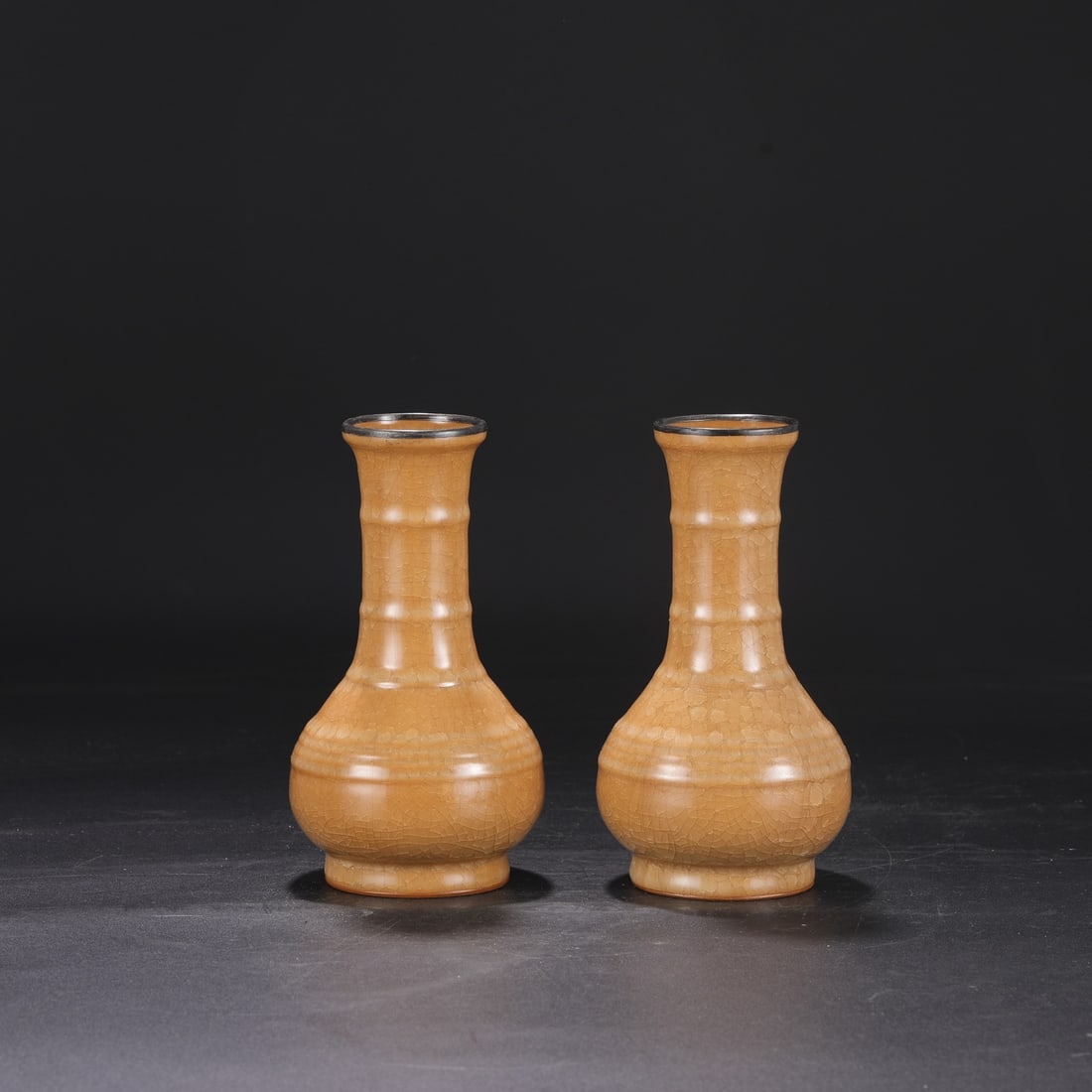 A pair of Southern Song Dynasty official kiln beige-glazed silver-rimmed vases with ice-crack: Dimensions: Height 20 cm, Mouth diameter 6 cm, Belly diameter 10.5 cm.