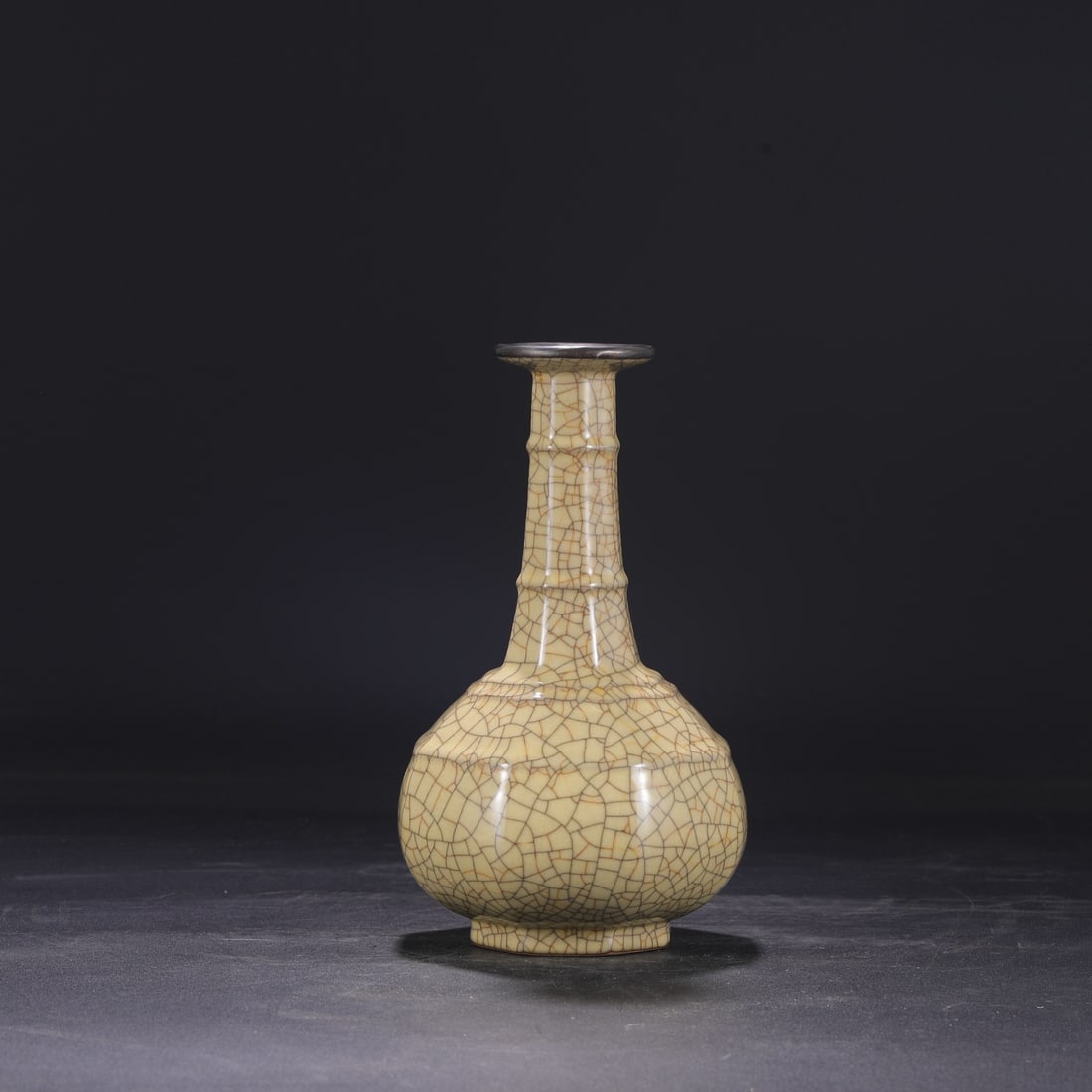 A Northern Song Dynasty Ge ware octagonal bamboo-shaped vase with a beige glaze and silver rim,: Dimensions: Height 24.5 cm, Mouth diameter 6 cm, Belly diameter 13 cm.