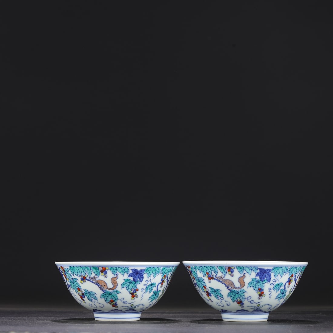 A pair of Ming Dynasty Chenghua doucai palace bowls with squirrel and grape design, formerly in the: Dimensions: Height 7 cm, Diameter 14.5 cm.
