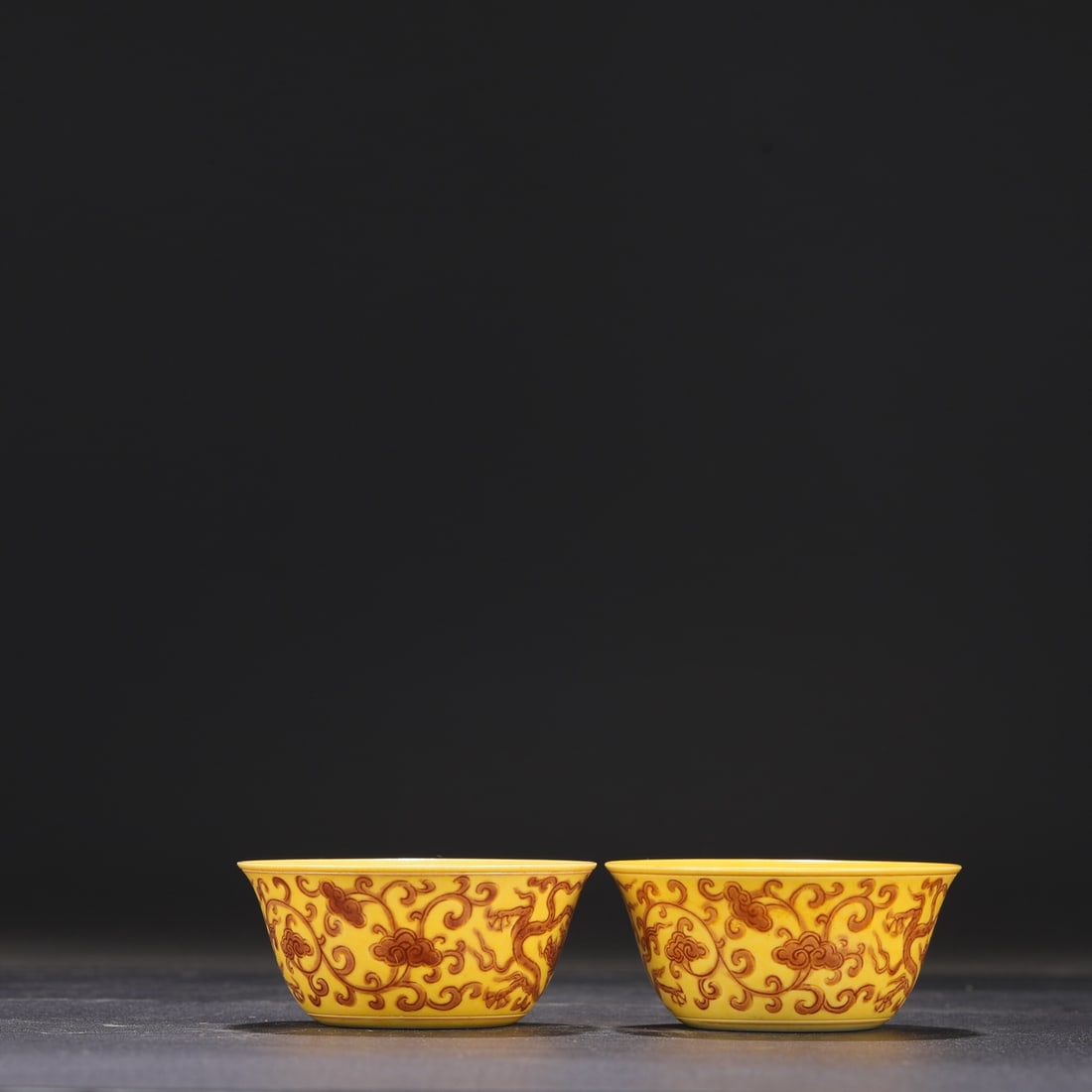 A pair of Ming Dynasty Chenghua period yellow-ground brown-painted lingzhi and dragon-patterned: Dimensions: Height 4 cm, Mouth Diameter 8.5 cm.