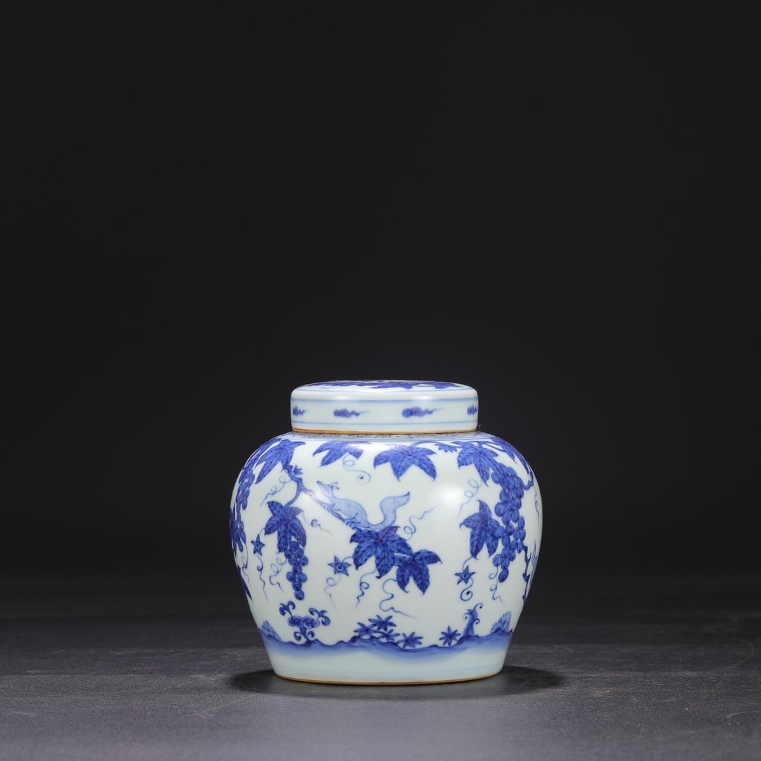 A Ming Dynasty Chenghua period blue and white porcelain covered jar with squirrel and grape design: Dimensions: Height 14.5 cm, Mouth diameter 7 cm, Belly diameter 14.5 cm.