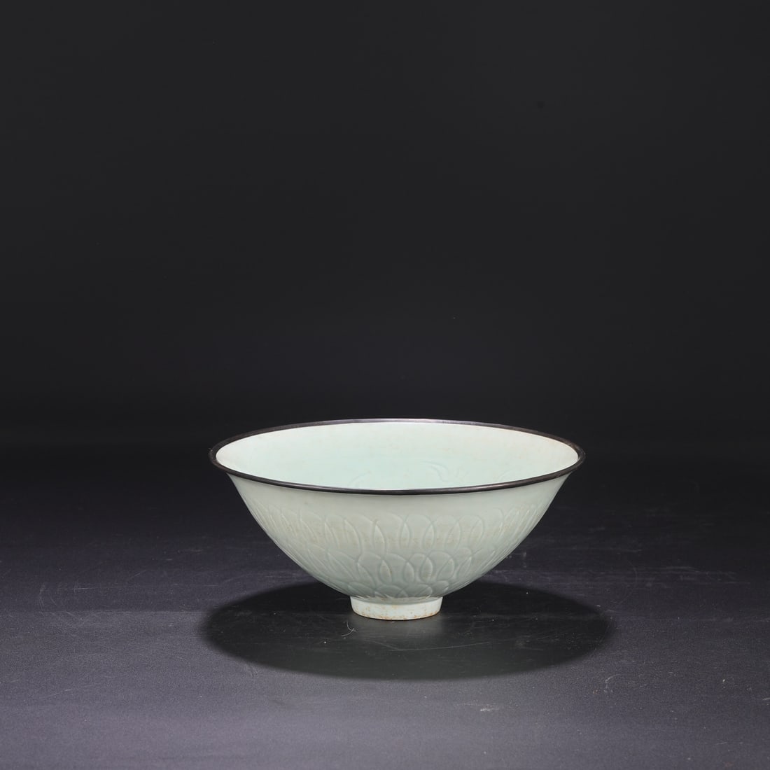 A large, deep-bodied silver bowl with a celadon rim and carved floral design, formerly from the: Dimensions: Height 11.5 cm, Diameter 24.5 cm.